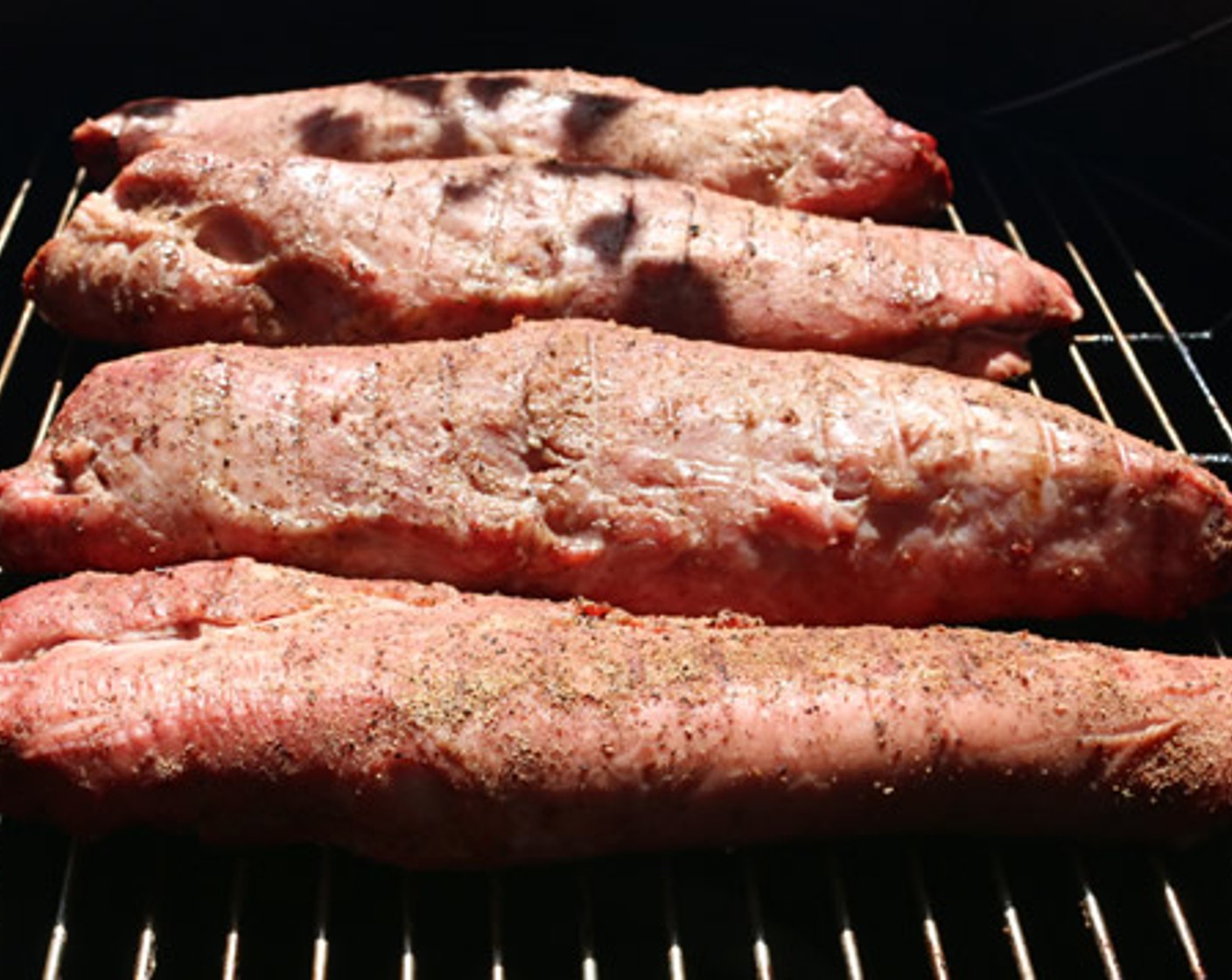 step 7 Remove any excess fat or silver skin from each Pork Tenderloin (4). Season with the Jerk Rub on all sides.Place each tenderloin on the cooking rack of the smoker and insert probe thermometer to monitor internal temperature.