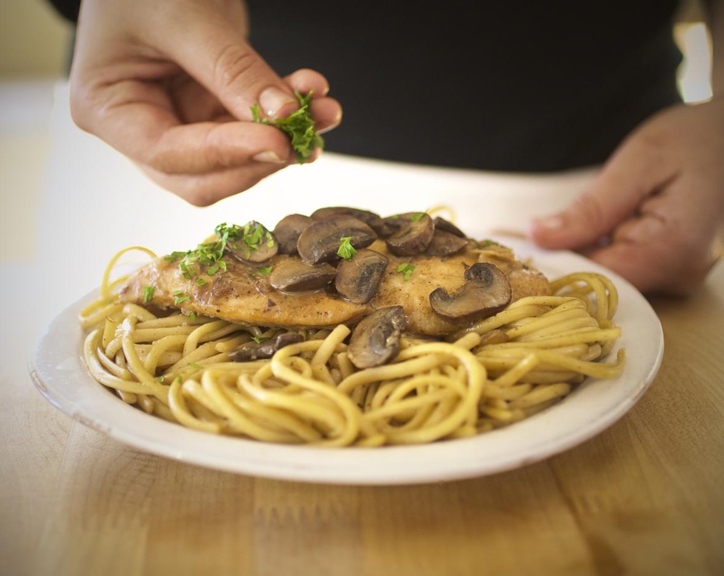 step 14 Cut the chicken into 1/4 inch slices on the bias. Place equal amounts of linguine off-center on two plates. Fan the chicken slices out over the pasta. Top with more mushrooms and sauce. Arrange the broccoli in a separate bowl. Garnish with the parsley leaves. Serve and enjoy!