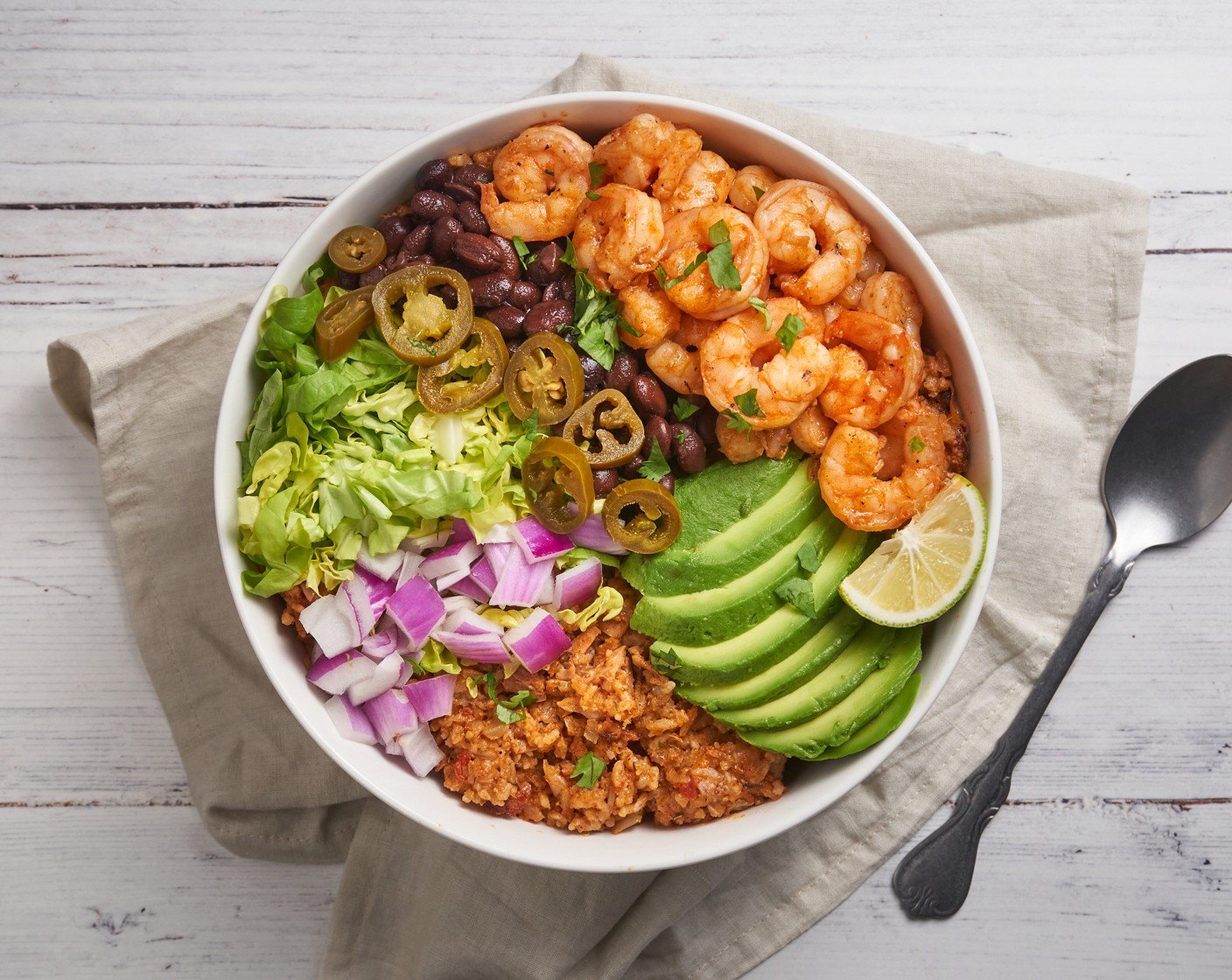 step 5 Transfer jambalaya rice to a serving bowl. Top with Lettuce (2 cups), Black Beans (1 can), Avocados (3), Red Onion (1), Pickled Jalapeño Pepper (1 cup), and Fresh Cilantro (1/2 bunch). Enjoy it warm.