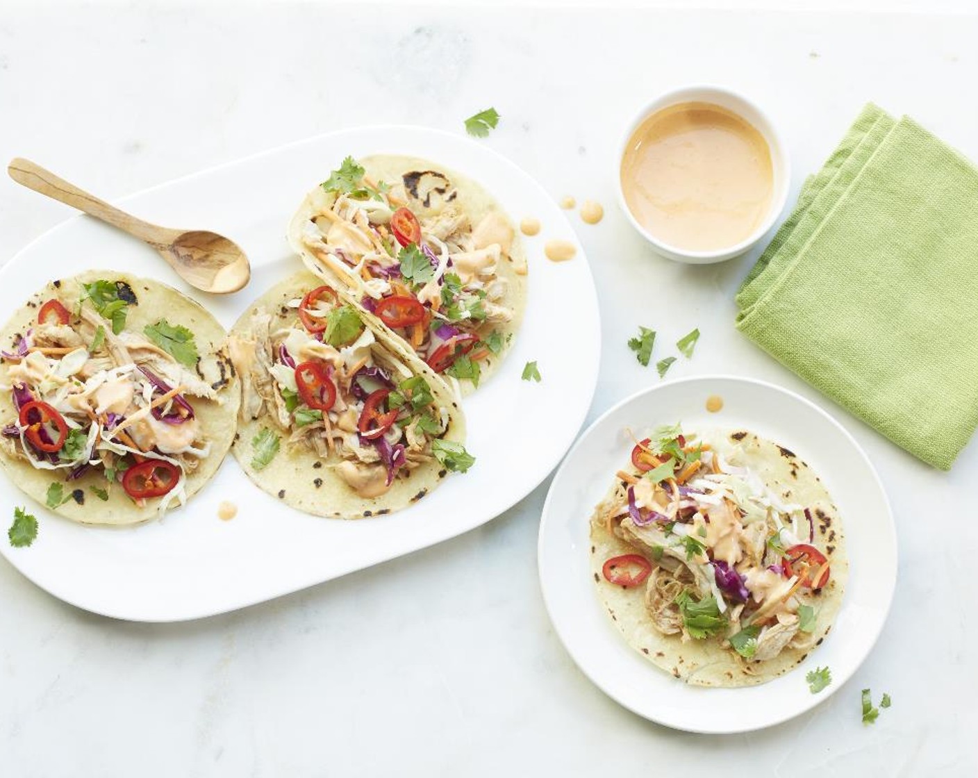 step 9 Place the chicken into the tortillas and top with the slaw and sriracha mayonnaise. Garnish with cilantro. Serve and enjoy!