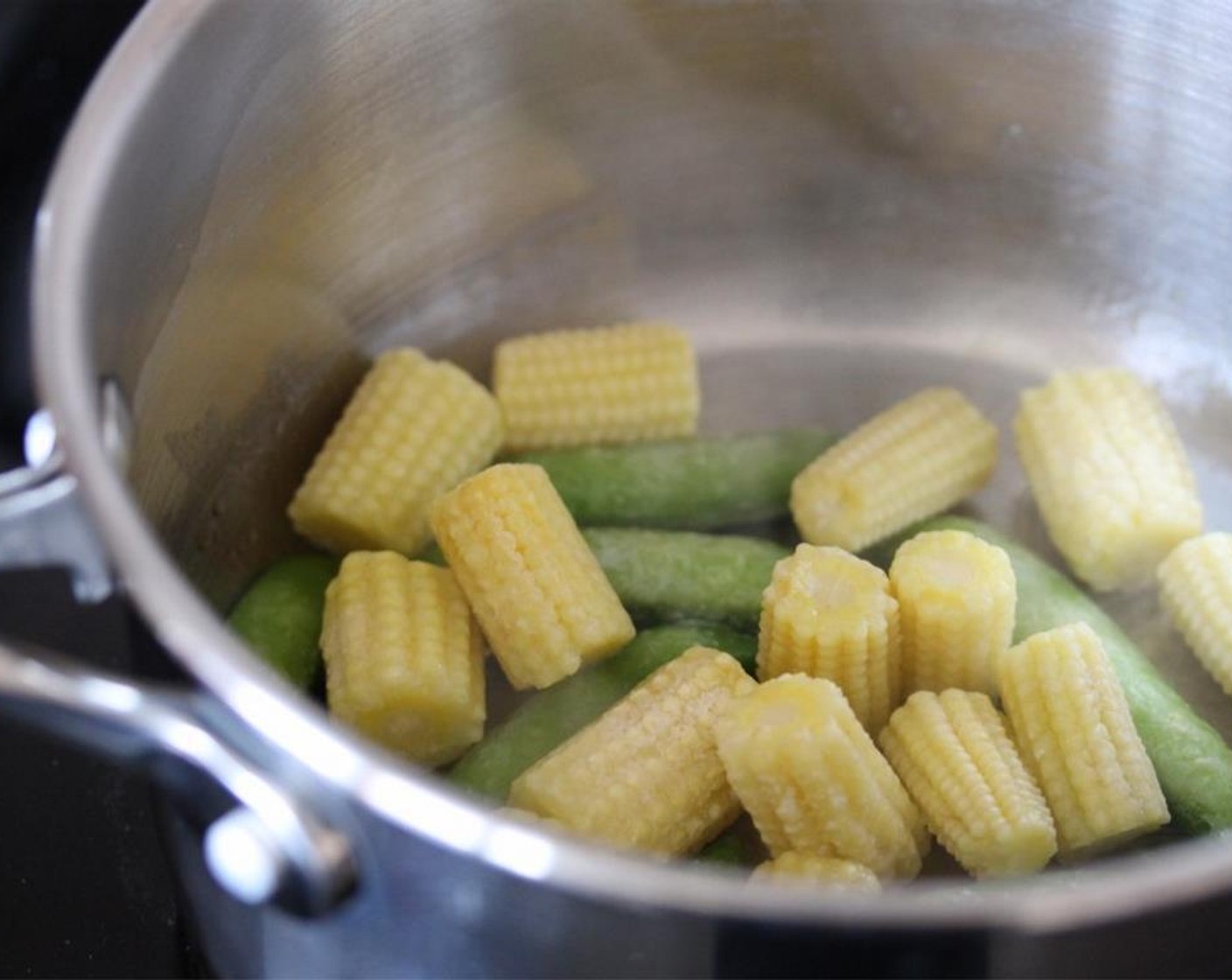 step 2 Place the Frozen Sugar Snap Peas and Baby Sweetcorn (1/4 pckg) into a saucepan over a low heat and stir occasionally until warmed through.