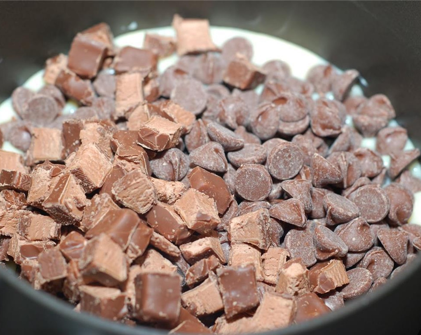 step 3 In a medium saucepan over low heat, combine the Sweetened Condensed Milk (1 1/3 cups), Milk Chocolate Chips (1 1/3 cups), and half of the chopped 3 Musketeers bars. Heat and stir until all chocolate is completely melted and the mixture is almost smooth.