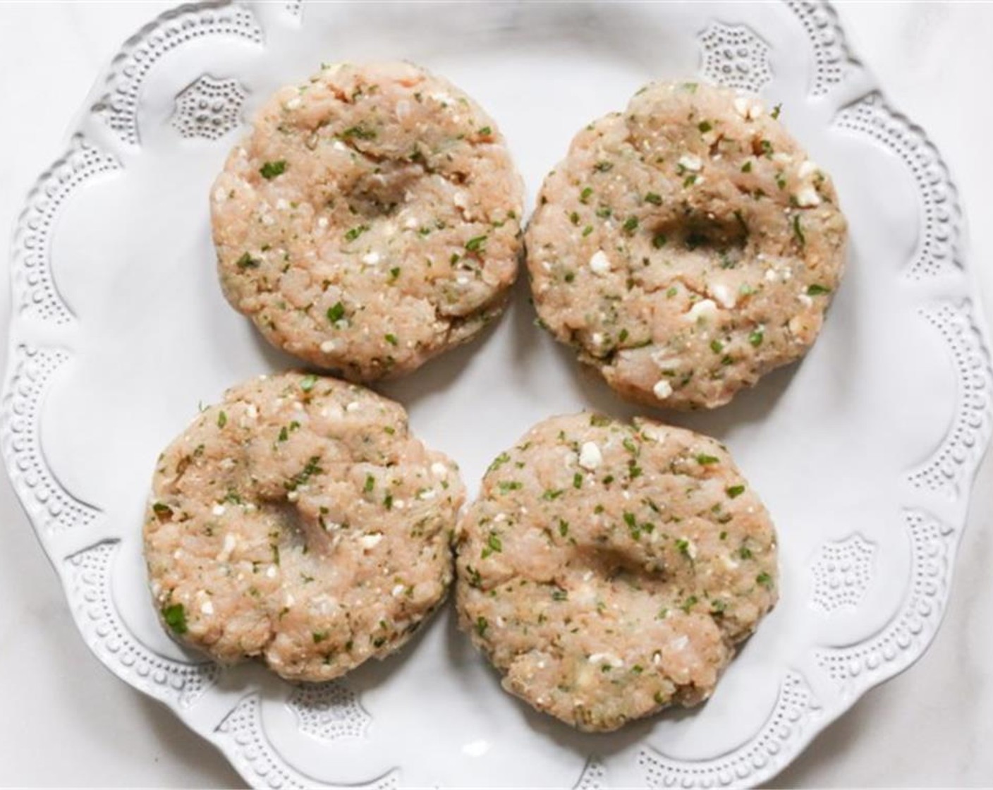 step 4 Gently form the turkey mixture into four patties, approximately ¾-inch thick. Using your thumb, make a small indent in the center of each patty.