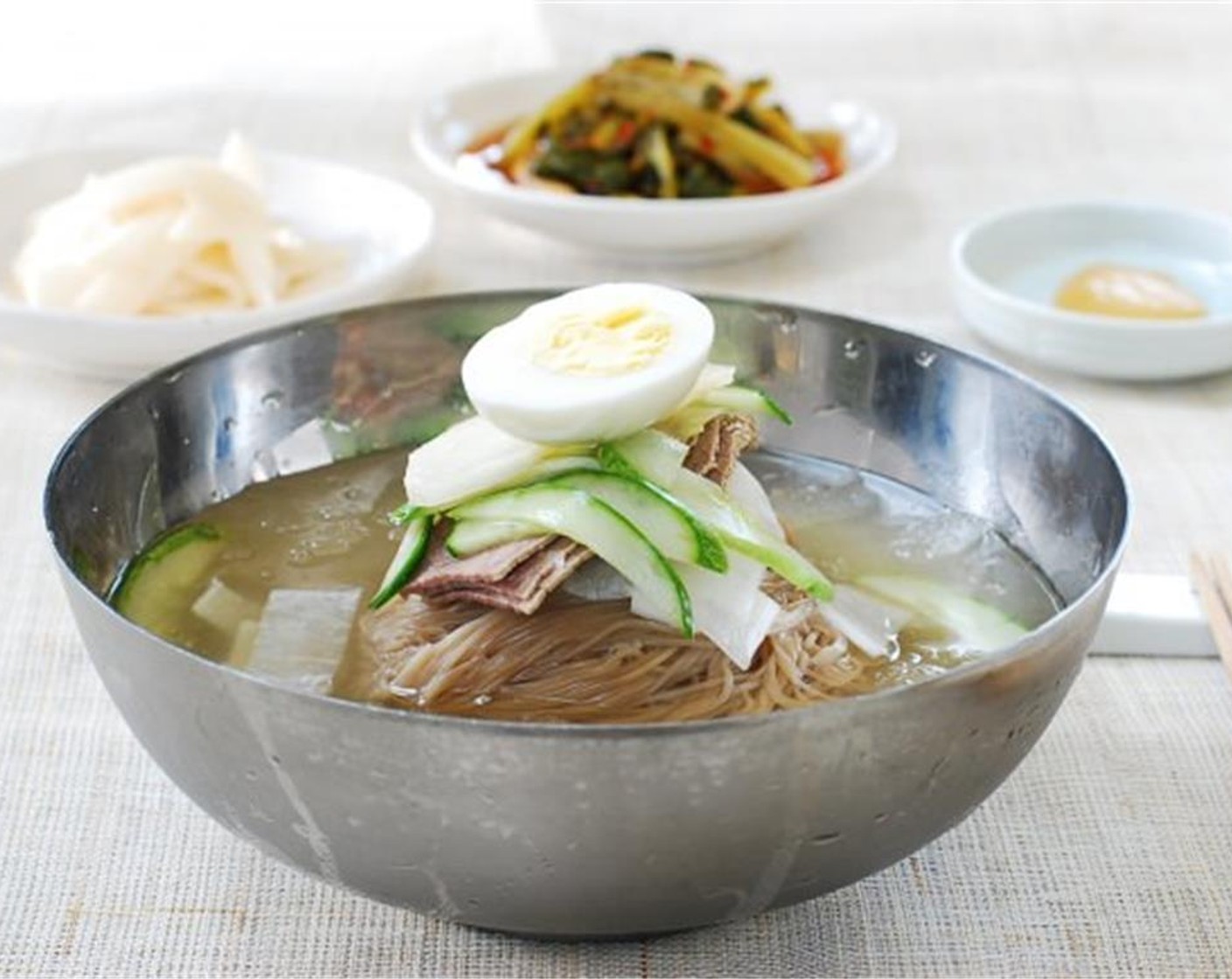 step 13 Pour one half of the icy broth around the noodles. Repeat for another serving. Serve with Distilled White Vinegar (to taste) and Korean Hot Mustard Paste (to taste) on the side.