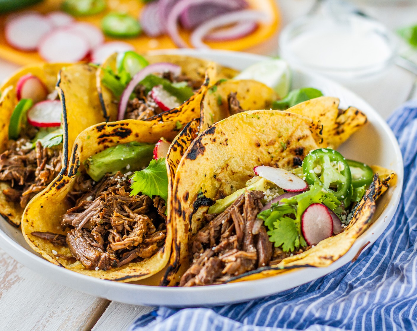 step 6 Serve barbacoa with Yellow Corn Tortillas (16) and garnish with Avocados (2), Fresh Cilantro (1/2 bunch), and Onion (1/2).