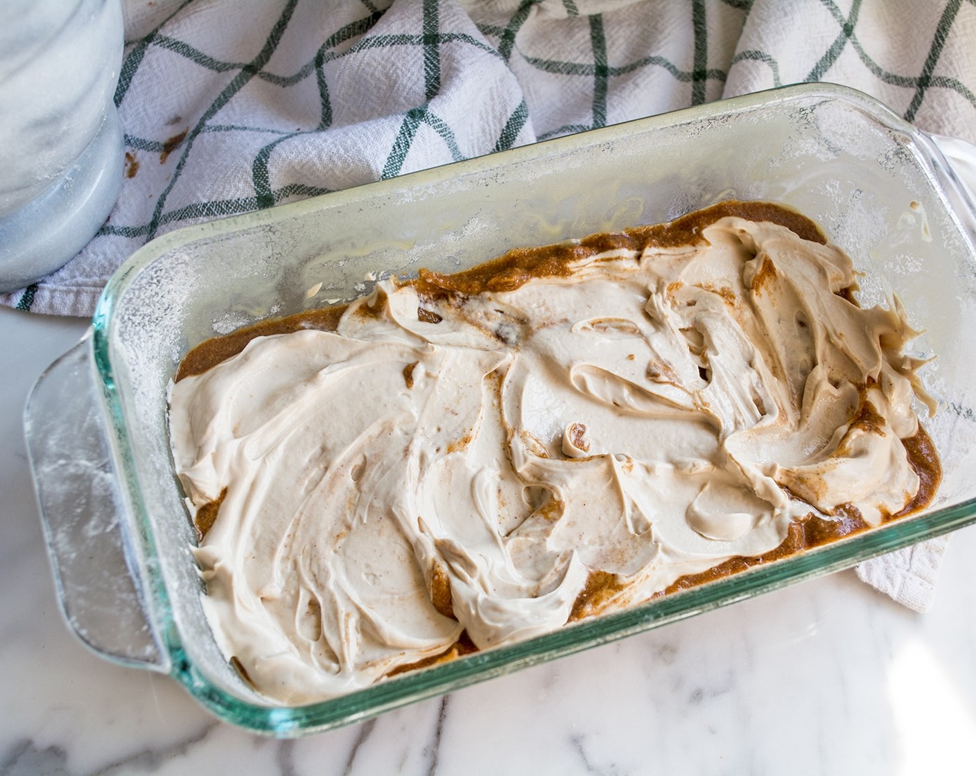 step 6 Pour half of the batter into greased and floured pan, then spoon cream cheese filling over batter and spread into even layer. Add remaining batter and cover filling completely.