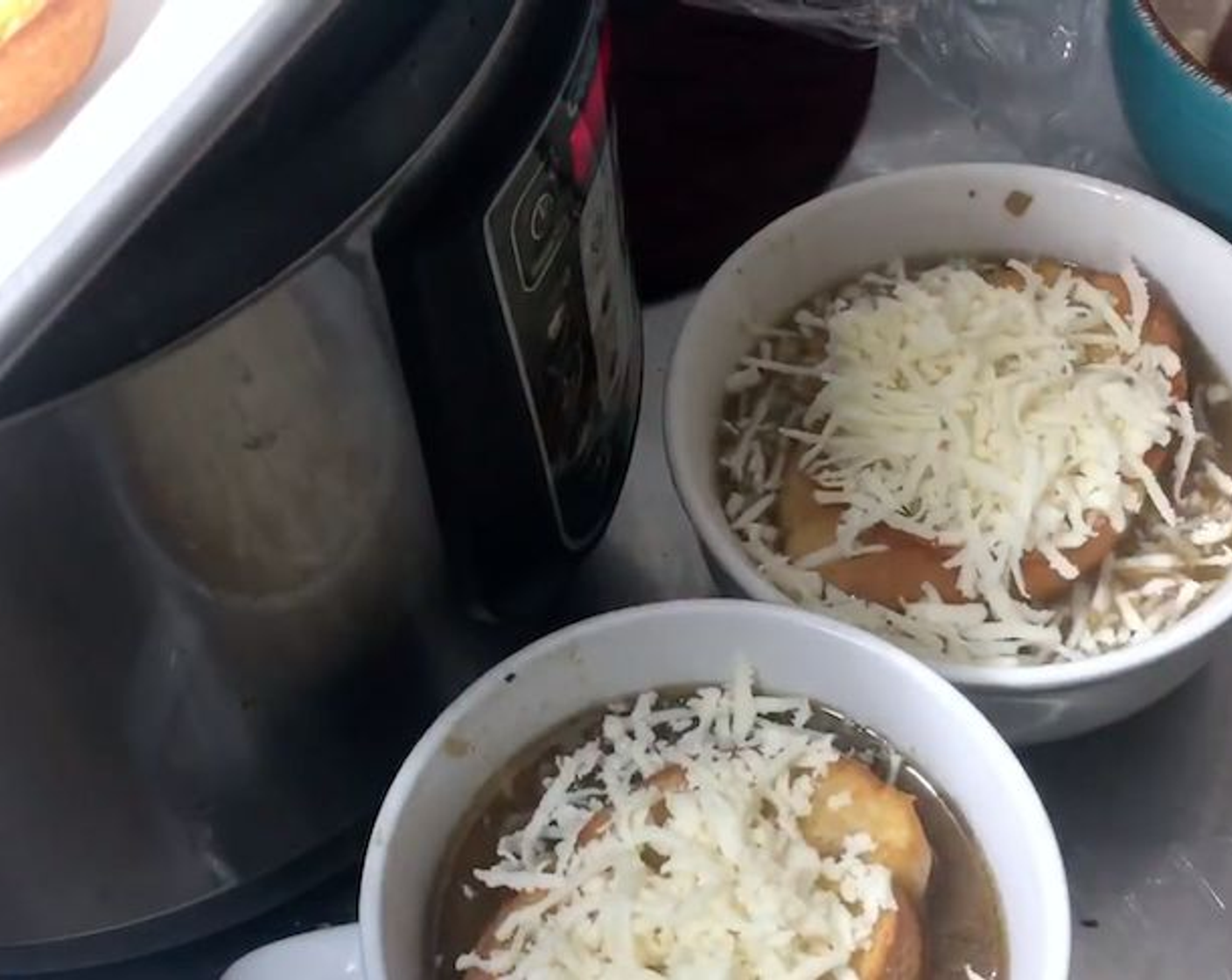 step 8 Serve in oven-safe bowls, top with a slice of French bread and Mozzarella Cheese (to taste) then place in oven on broil on a baking tray for about 5 minutes.