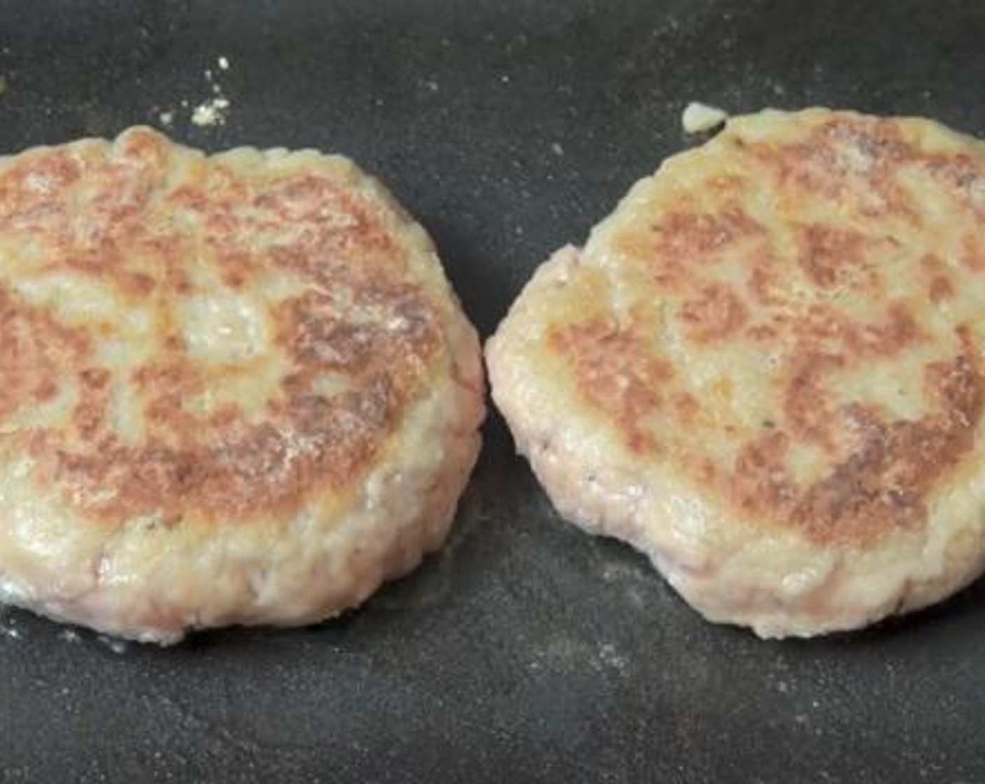 step 2 Divide the mixture into four portions, and form each portion into a patty. Dust each patty with some flour, and transfer it to a greased baking tray. Cook inside an electric skillet under medium heat for about 3 minutes on each side.