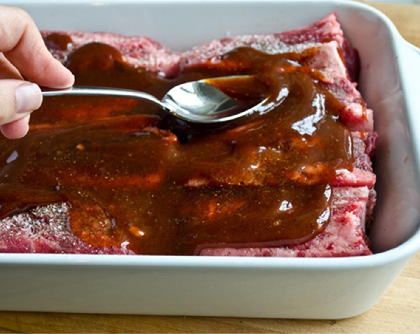 step 4 Pour one-third of the sauce over the short ribs. Using tongs, flip the ribs over and spoon another one-third of the sauce over top. Reserve the remaining BBQ sauce to spoon over the cooked ribs.