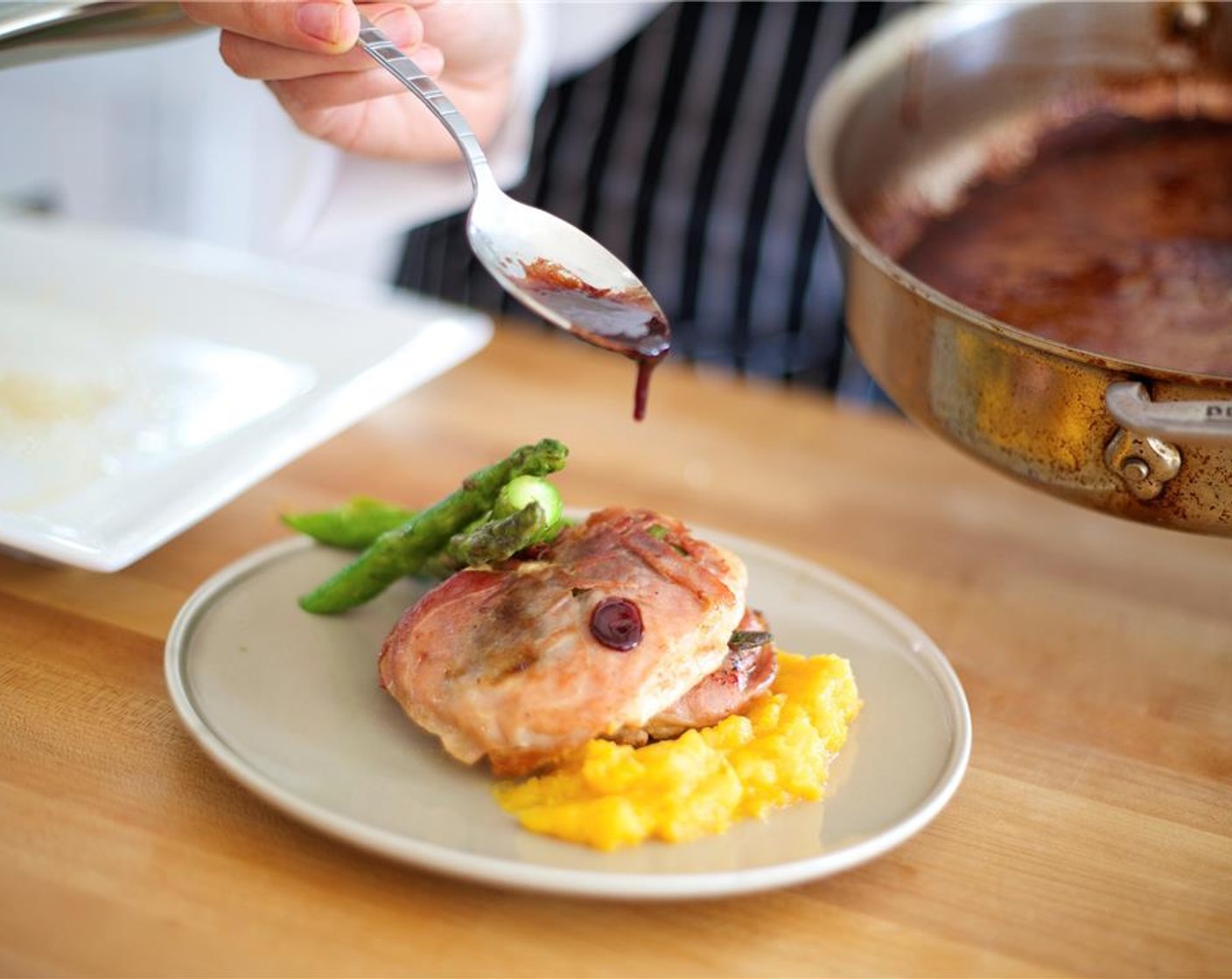 step 11 Lay two cutlets over the squash side by side, slightly overlapping. Plate the asparagus behind the turkey by stacking them with height. Drizzle port reduction over the cutlets.