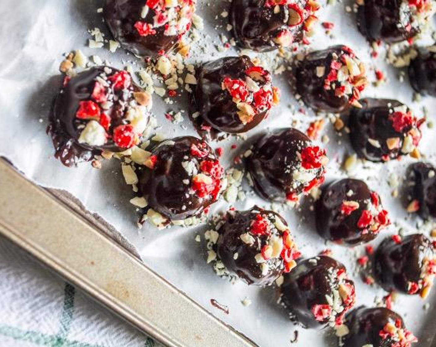 step 6 Once chocolate has melted, use a toothpick to dip each ball into the chocolate, tap on the side of the pan to remove extra chocolate, then place back on wax paper, garnish with White Chocolate (1/3 cup) and French Burnt Peanuts (1/4 cup).