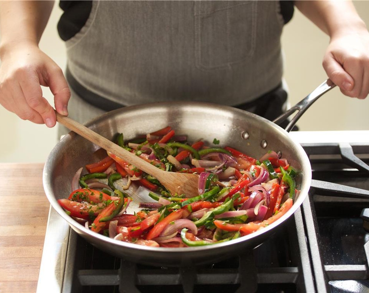 step 12 Meanwhile, in a large saute pan over high heat add 1 Tbsp Olive Oil. Once hot, add the pepper and onion mixture and Salt (1 tsp) and cook for 5 minutes.