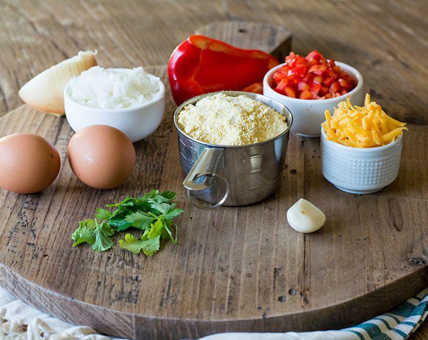 step 2 Combine Cornmeal (1 cup), Garlic (1 clove), Cheddar Cheese (1/3 cup), Almond Milk (1/2 cup), Sea Salt (1/2 tsp), Ground Black Pepper (1/2 tsp), Cayenne Pepper (1/8 tsp), Fresh Cilantro (1 Tbsp) into a large bowl.