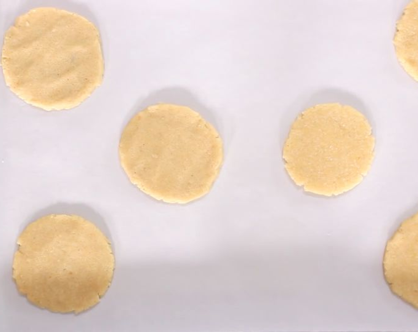 step 7 Knead the mixture then roll it out to 5mm thick. Using a small cookie cutter, cut out circles and put onto a non-stick baking tray. Bake for about 25 minutes until they are coloured slightly. You want the biscuit to be hardened a bit on the bottom but soft on the top as when it cools it will harden. Leave to cool on a wire rack until ready to serve.