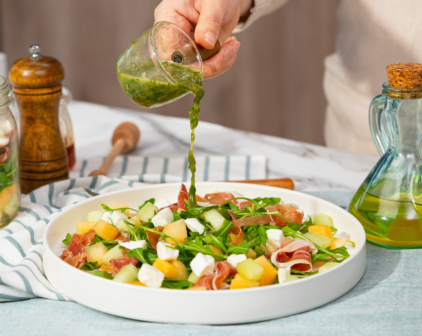 step 3 Arrange the Arugula (5 2/3 cups), Prosciutto (6 oz) cantaloupe, melon, and Fresh Mozzarella Cheese Ball (2/3 cup) on the serving plate. Drizzle with mint basil vinaigrette. Serve.