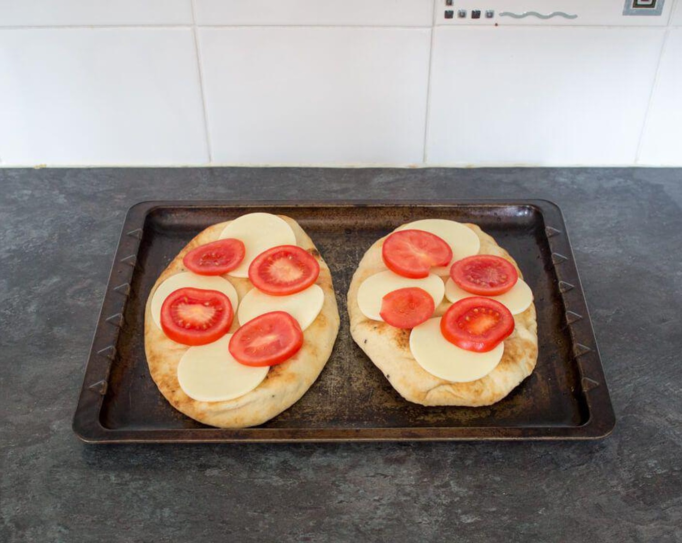 step 4 Lay Tomato (1) over the mozzarella on each Naan Pizza.
