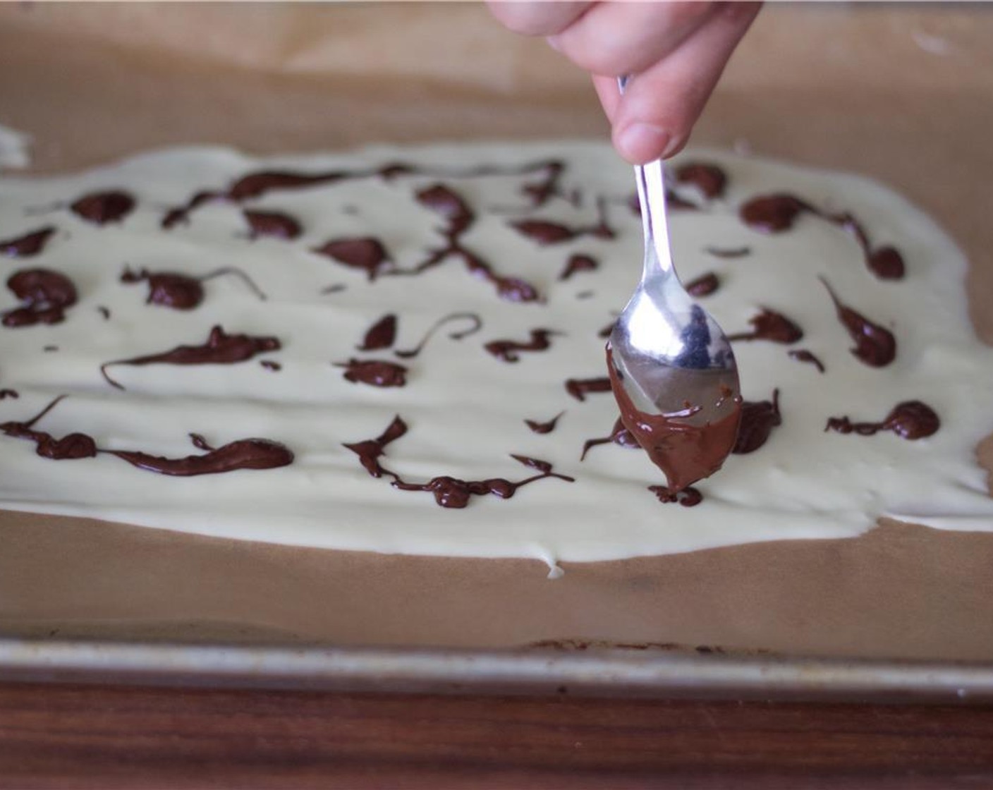 step 4 Using a spoon, quickly make dots and patterns on top of the white chocolate.