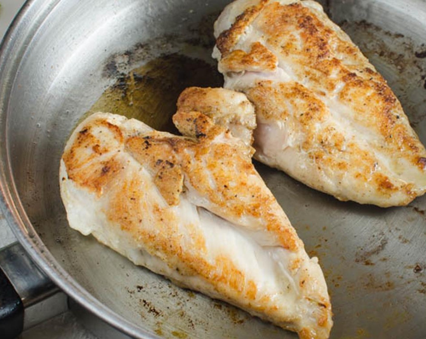 step 2 In a skillet over medium high heat, add the Olive Oil (2 Tbsp). Carefully add the organic chicken breasts to the hot skillet and cook for 3-4 minutes on each side until golden brown. Transfer organic chicken breasts to a plate.