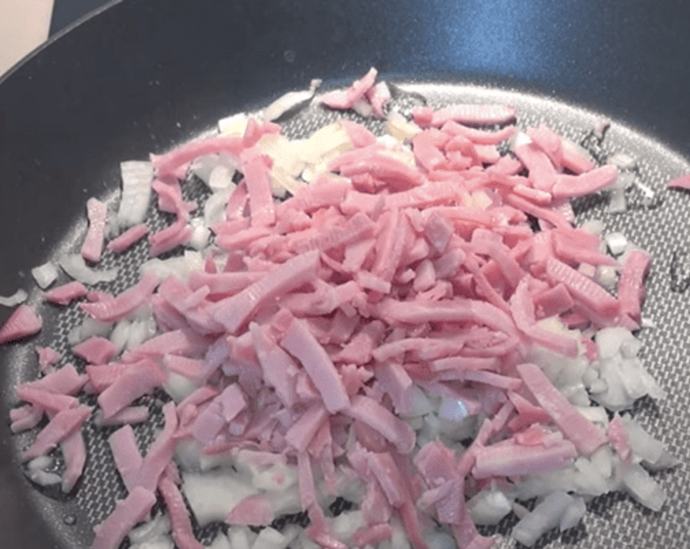 step 1 Got one Yellow Onions (to taste) which is just diced up and a handful of shredded Ham (to taste). Cook them over a medium heat in lightly greased fry pan until the onions are lightly brown and ham is heated through.