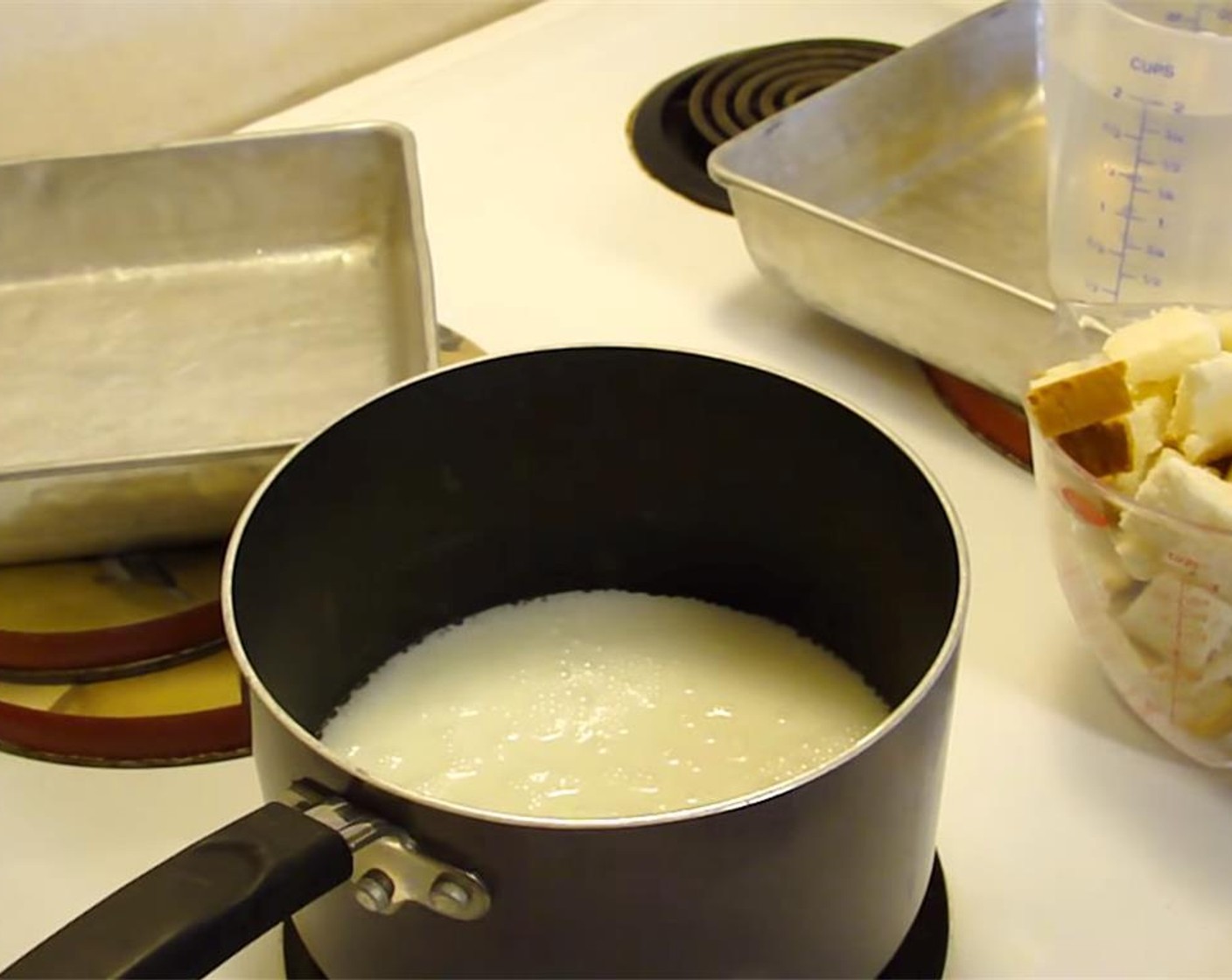 step 1 Preheat oven to 350 degrees F (180 degrees C). Cube the Bread (2 cups). Make sure to compress it, so there is just a little more than the suggested amount.  In a small bowl, lightly beat the Eggs (4). Heat Milk (2 cups) to scalding in a pan on the stove top.