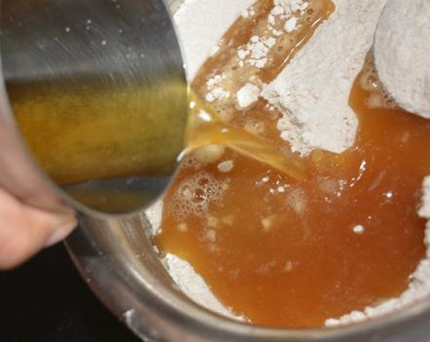 step 2 Take Whole Wheat Flour (1 cup) in another pan and add the cooled jaggery water and mix well so that it doesn't form any lumps.