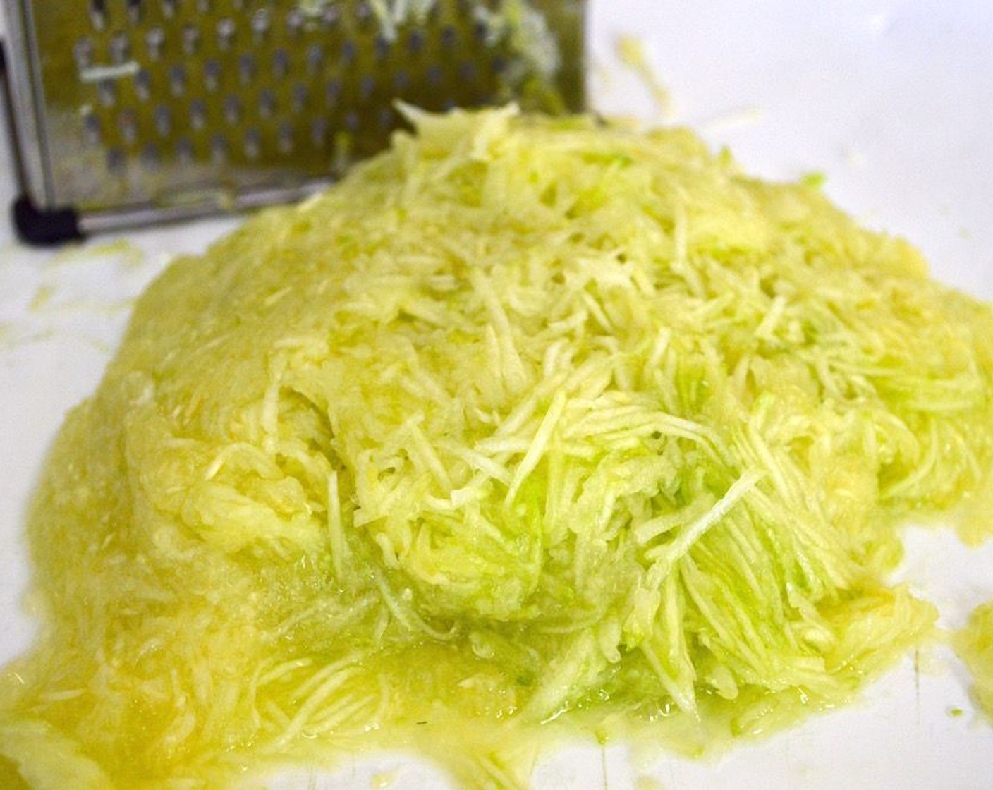 step 2 Peel Zucchini (2 cups) and grate on the smallest hole of a box grater, then blot dry with a paper towel.