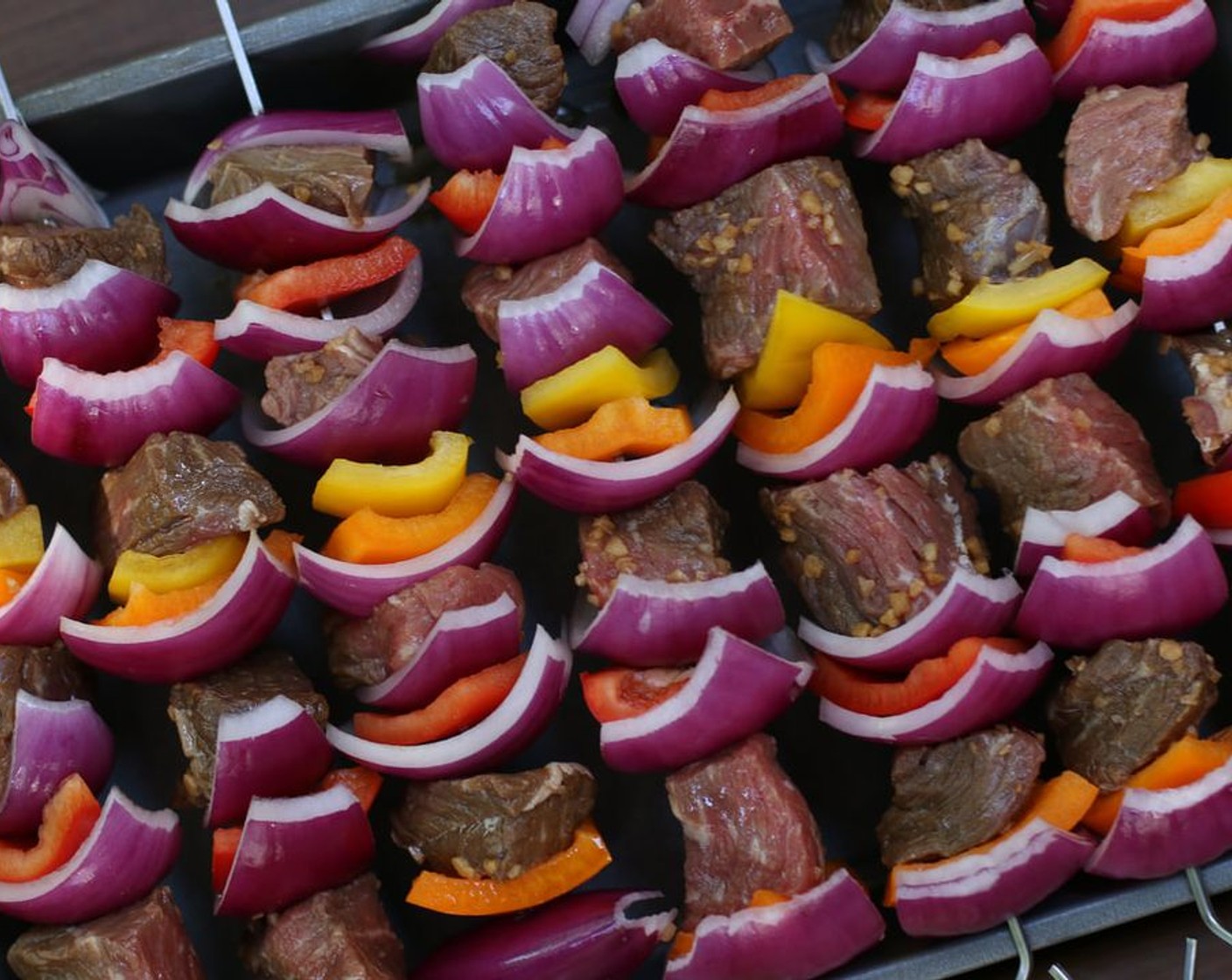 step 9 If using wooden skewers, soak in water for at least 30 minutes before grilling or broiling. If using metal skewers, skewer away. Thread marinated beef and Red Bell Peppers (2), Orange Bell Peppers (2), Yellow Bell Peppers (2), and Red Onion (1) onto skewers.