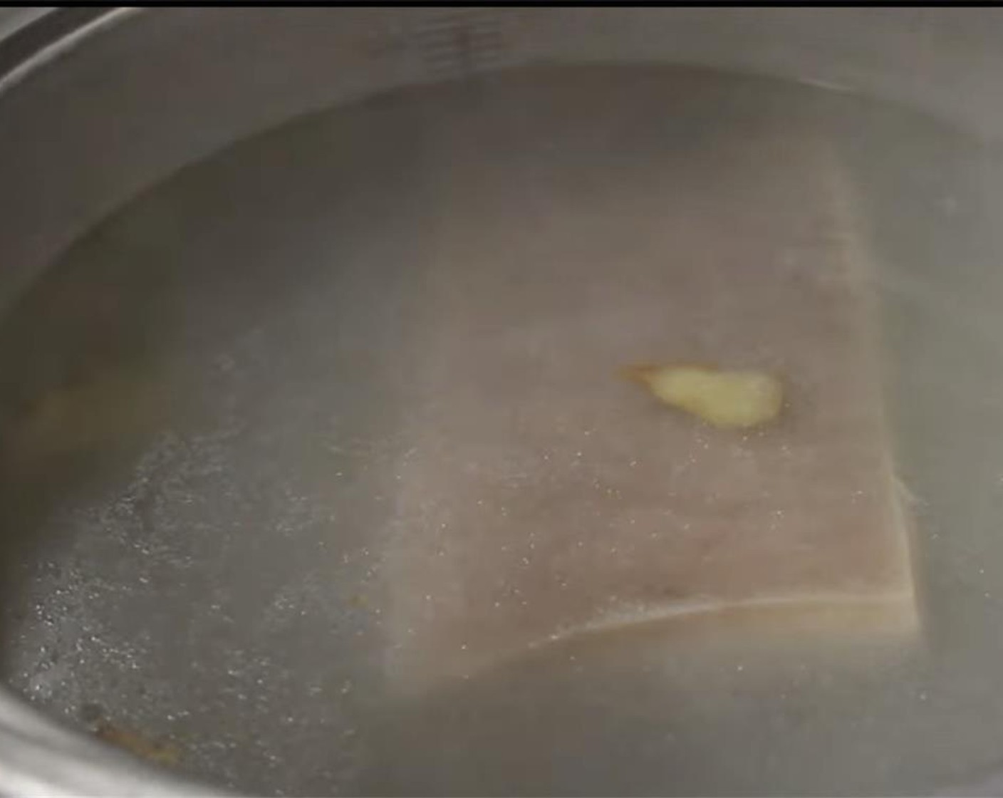 step 2 Boil the Fresh Ginger (2 slices) and Scallion (1 bunch) in water for a few minutes to extract the flavor. Add in the belly and cook for 7 minutes at medium high with lid on. Prepare a dish with Water (to taste) to place the pork belly in after.