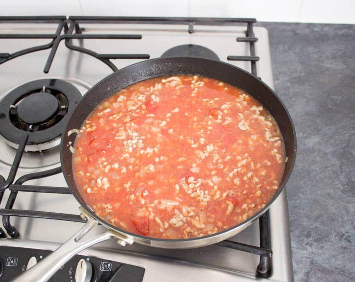 step 4 Add the Canned Chopped Tomatoes (2 cups) then fill the empty can with water and pour this in too. Add in the Canned Tomato Purée (4 Tbsp) and season with a generous amount of Salt (to taste) and Simply Organic® Black Pepper (to taste).