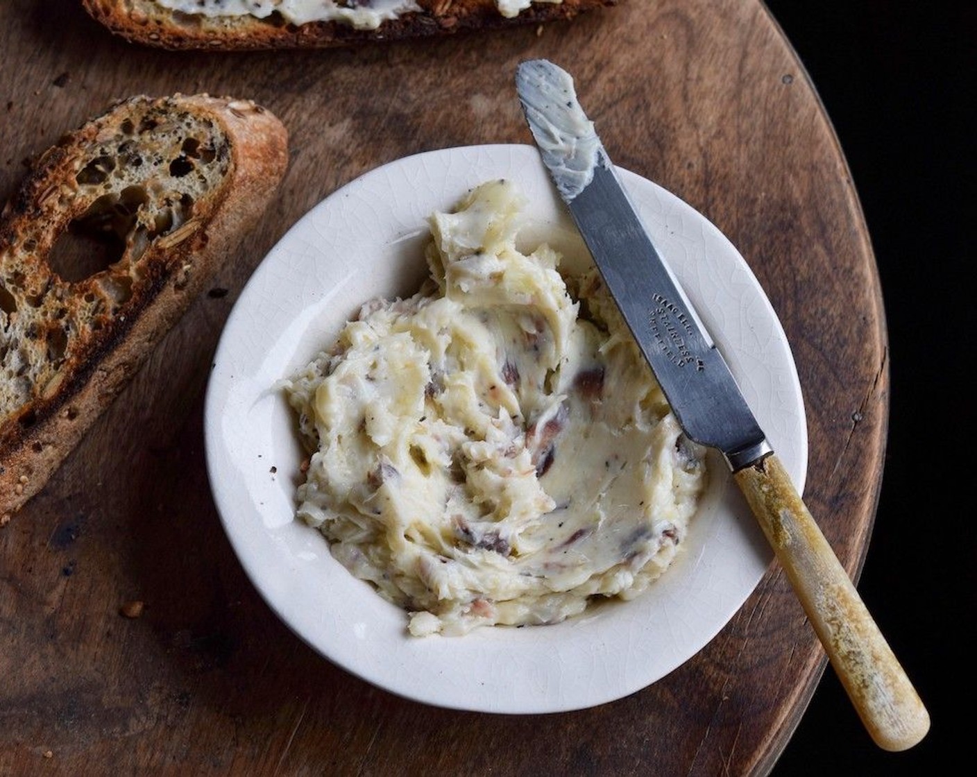 step 3 In a bowl, combine the Salted Butter (1 cup), Anchovy Fillets (6), and Garlic (3 cloves). Use a spoon to roughly mash the ingredients together and season with Ground Black Pepper (to taste).