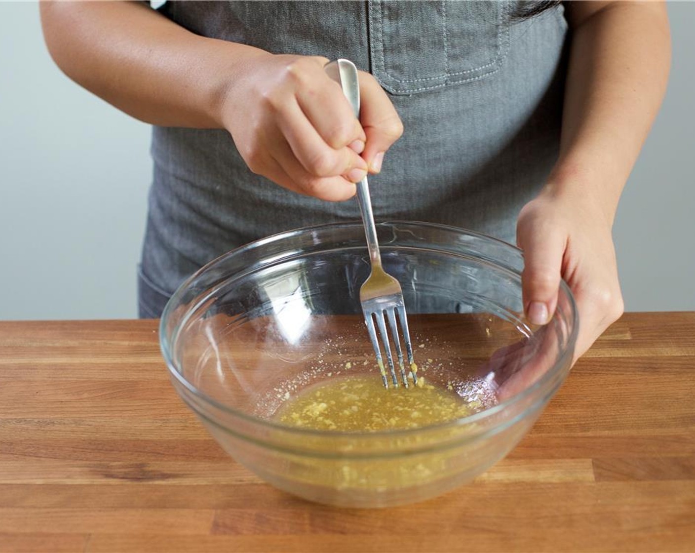 step 6 Slowly drizzle in two tablespoons of olive oil while whisking to create the vinaigrette.