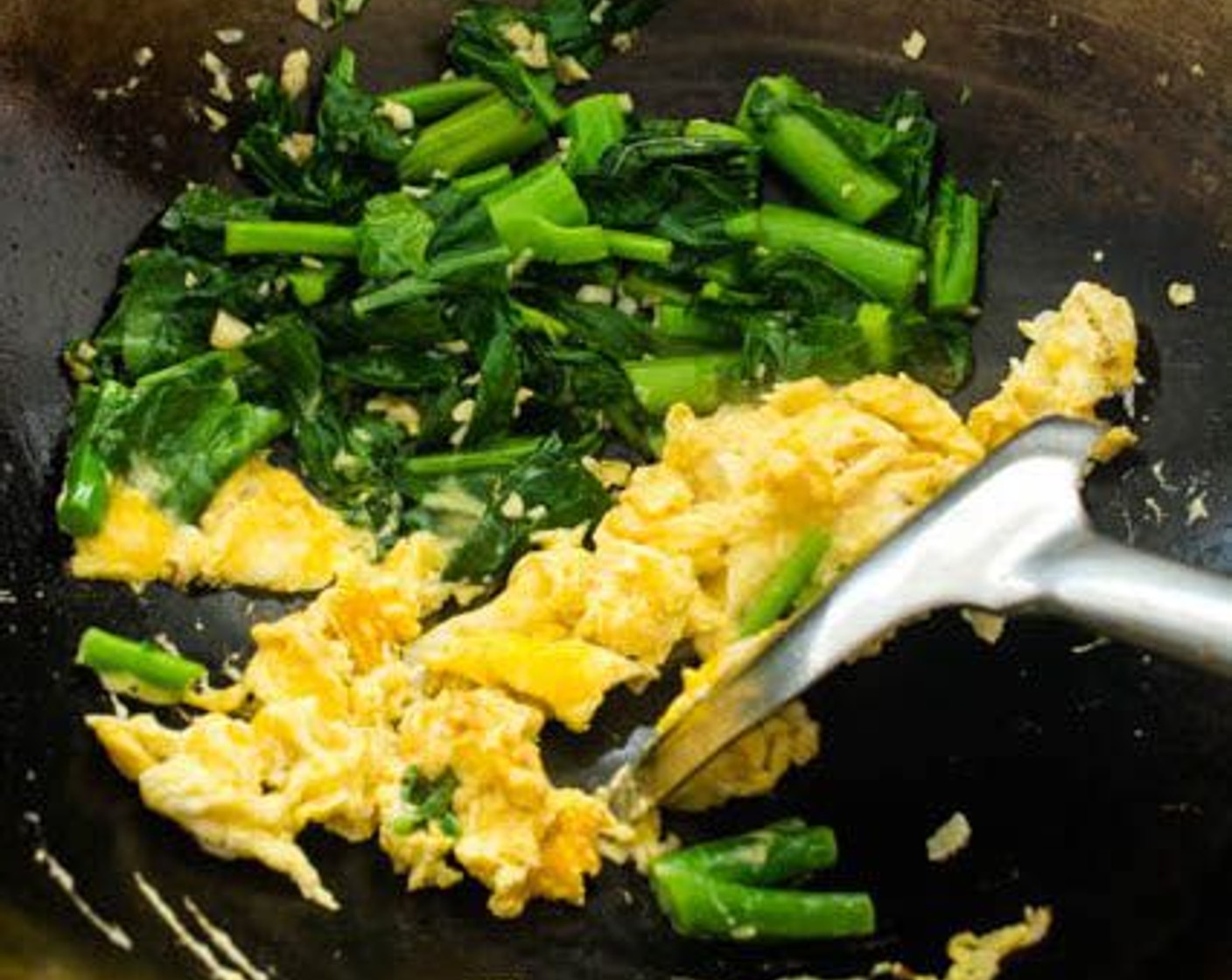 step 10 Pour the Eggs (2) into the middle of the wok. Leave the eggs untouched for about 20 seconds to allow the bottom to set, flip, then scramble the eggs.