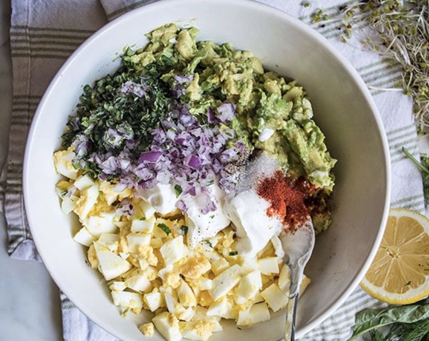 step 2 Add Eggs (5), Plain Greek Yogurt (3 Tbsp), Red Onions (2 Tbsp), Scallion (1 Tbsp), Fresh Basil (1 Tbsp), Fresh Dill (1 tsp), 2 Tbsp Lemon (1), Fine Sea Salt (1/2 tsp), Ground Black Pepper (1/4 tsp), and Smoked Paprika (1/4 tsp).