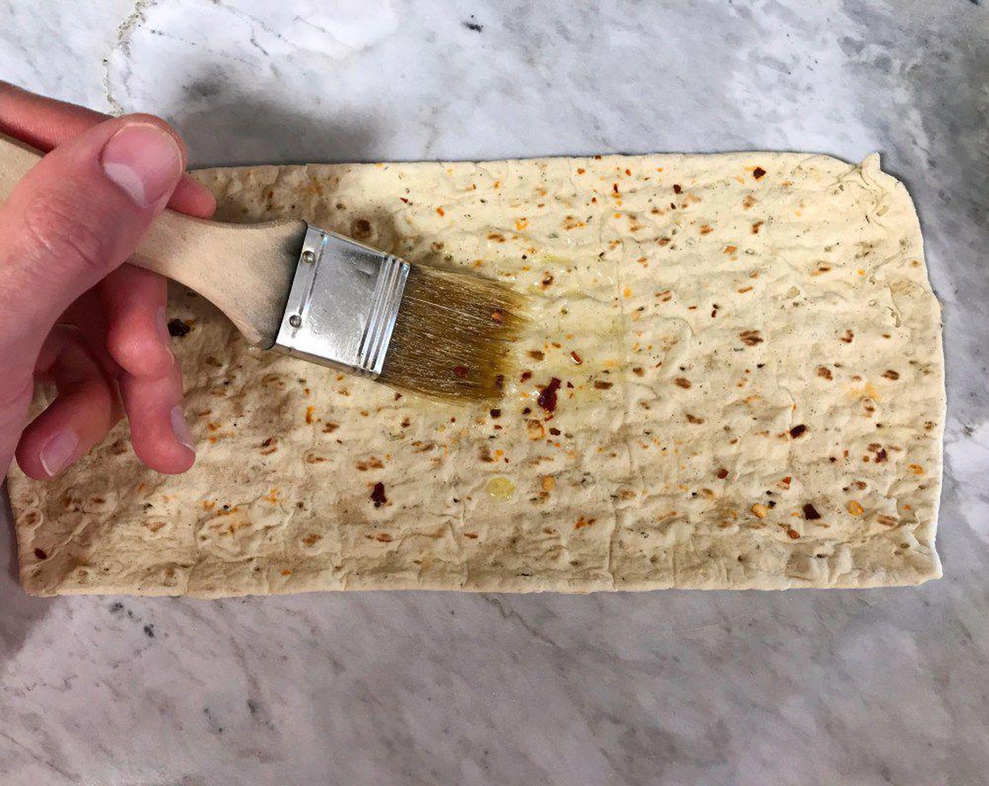 step 3 Brush the bottom of the Flatbread (1) generously with Extra-Virgin Olive Oil (1 Tbsp). This will help keep the flatbread from sticking to the aluminum foil. Cut a sheet of aluminum foil a few inches longer than the perimeter of your flatbread. Lay the oiled side of the flatbread face down on the foil.