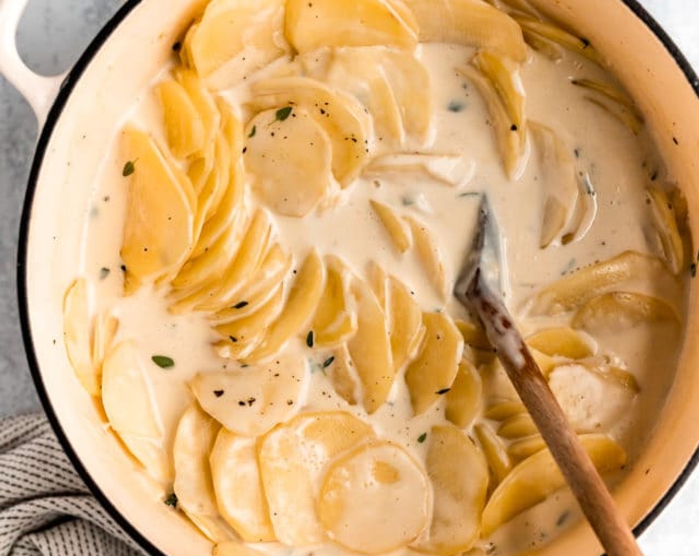 step 3 Transfer Yukon Gold Potatoes (12 cups) and garlic to a large pot with Heavy Cream (2 cups), Whole Milk (2 cups), Fresh Thyme Leaves (1 Tbsp), Coarse Salt (1/2 Tbsp), Freshly Ground Black Pepper (1/2 tsp), and Whole Nutmeg (1/8 tsp). Bring to a boil over high heat. Reduce heat to medium and simmer for 1 minute.