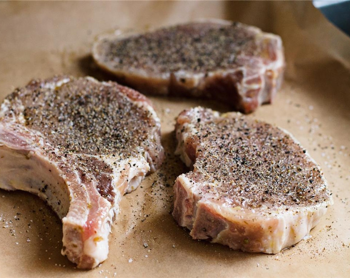 step 4 Remove pork chops from the brine and discard the brine. Prepare grill to medium-high heat. Rub or brush the pork chops with Extra-Virgin Olive Oil (2 Tbsp) and season with Kosher Salt (to taste) and Freshly Ground Black Pepper (to taste), being sure to season the bones as well.