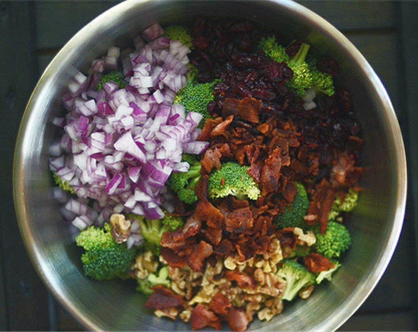 step 7 In a large bowl, combine bite-sized broccoli florets, bacon, Dried Cranberries (2/3 cup), roasted walnuts, and diced red onion. Toss to combine. Season with Salt (to taste) and Ground Black Pepper (to taste).