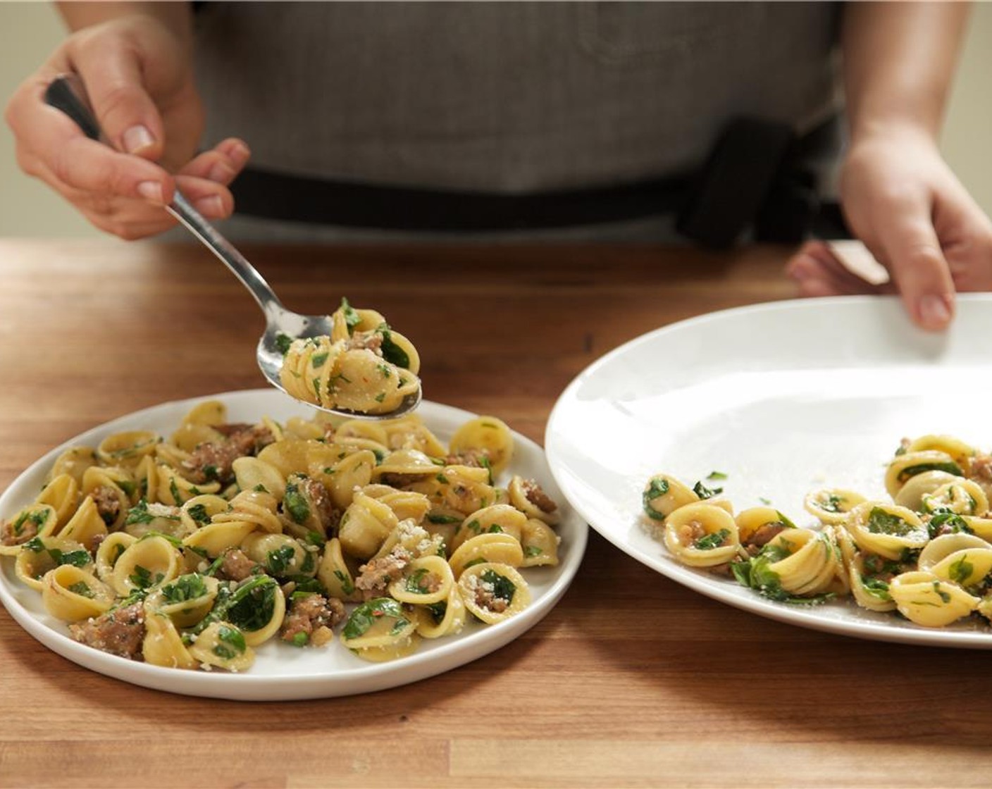 step 9 Evenly distribute the orecchiette pasta between two plates. Garnish with Parmesan Cheese (1/4 cup).