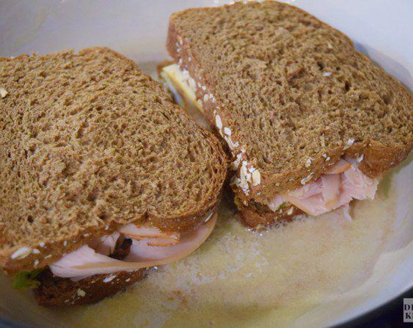 step 3 Melt Butter (1 Tbsp) in the skillet and add the sandwich to the pan. Cook the sandwich for about 2 minutes per side until it has a golden crust and the cheese is melty on the inside, adding more butter as needed.