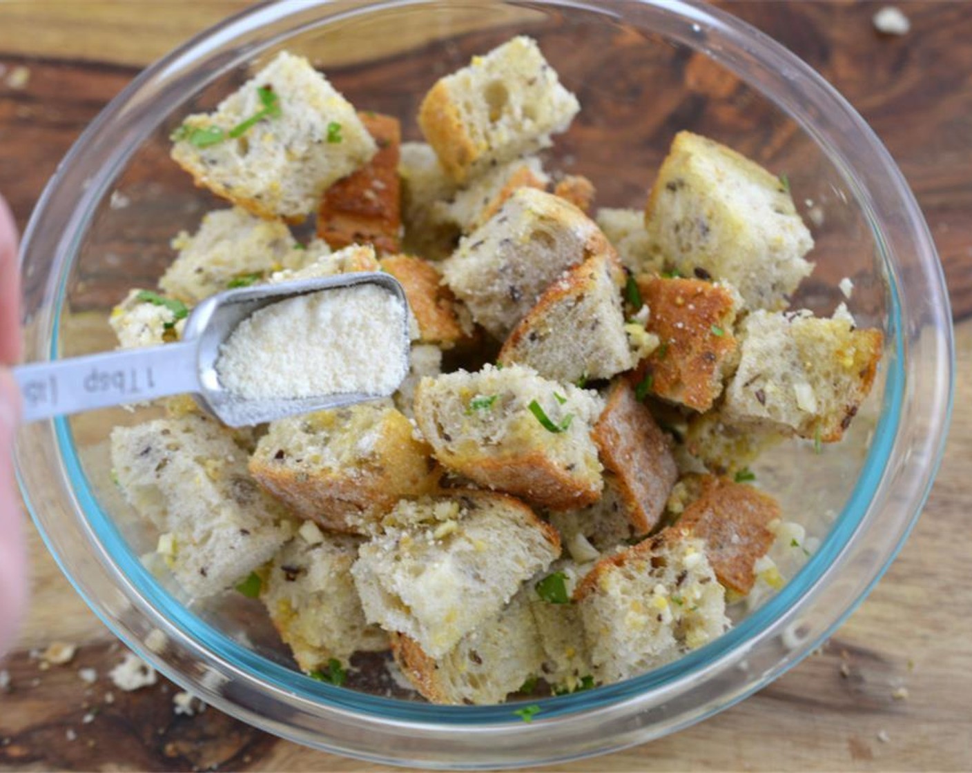 step 2 Add Whole Wheat Baguette (1) to a large bowl. Drizzle Extra-Virgin Olive Oil (2 Tbsp) over the bread and toss in Parmesan Cheese (1 Tbsp), Fresh Parsley (1 Tbsp), and Garlic (2 cloves). Place croutons on a baking sheet and cook for 15 minutes or until golden brown.