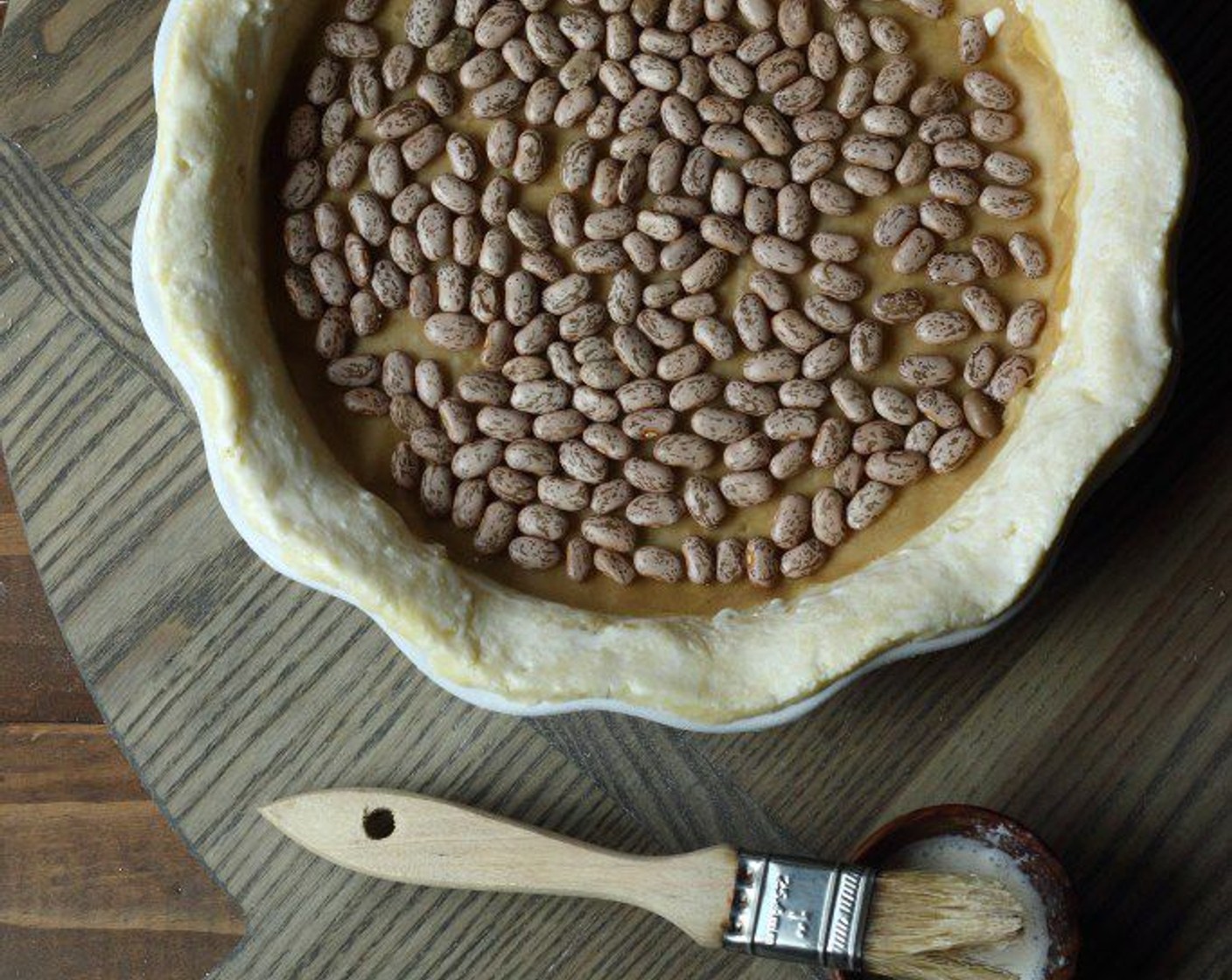 step 20 Place a round piece of parchment in the bottom of your crust and fill with pie weights (dried beans work well).