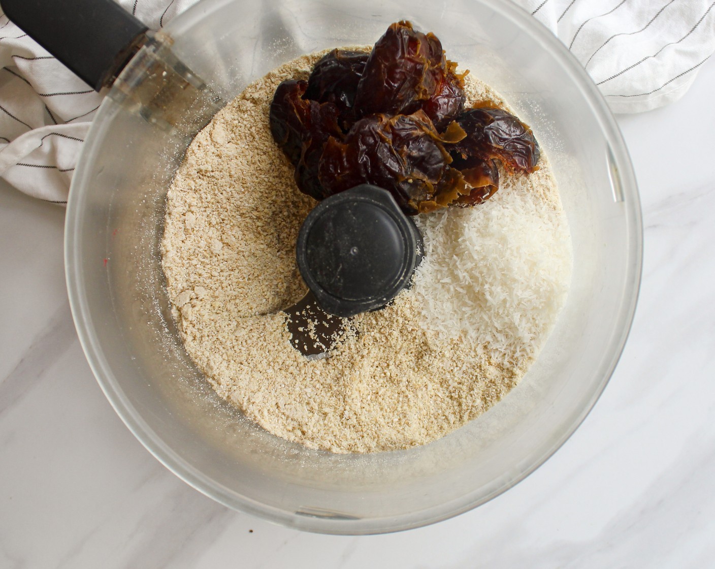 step 3 Place in the Unsweetened Shredded Coconut (1/4 cup), Vanilla Extract (1 tsp), including the dates together with 2 tablespoons of Water (2 Tbsp) and blend until smooth. You might need to add more water to achieve a sticky dough consistency, a tablespoon at a time.