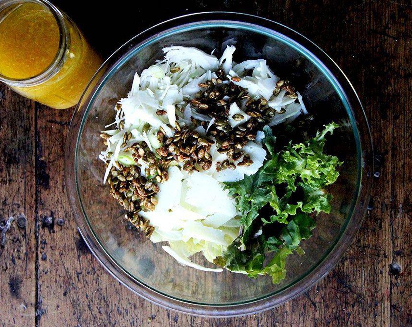 step 3 In a large bowl, combine the Green Cabbage (1/4 head), Fennel Bulb (1), Scallions (3 stalks), Baby Kale (3 handfuls), Candied Pepitas (to taste), Manchego Cheese (to taste) and Freshly Ground Black Pepper (to taste).