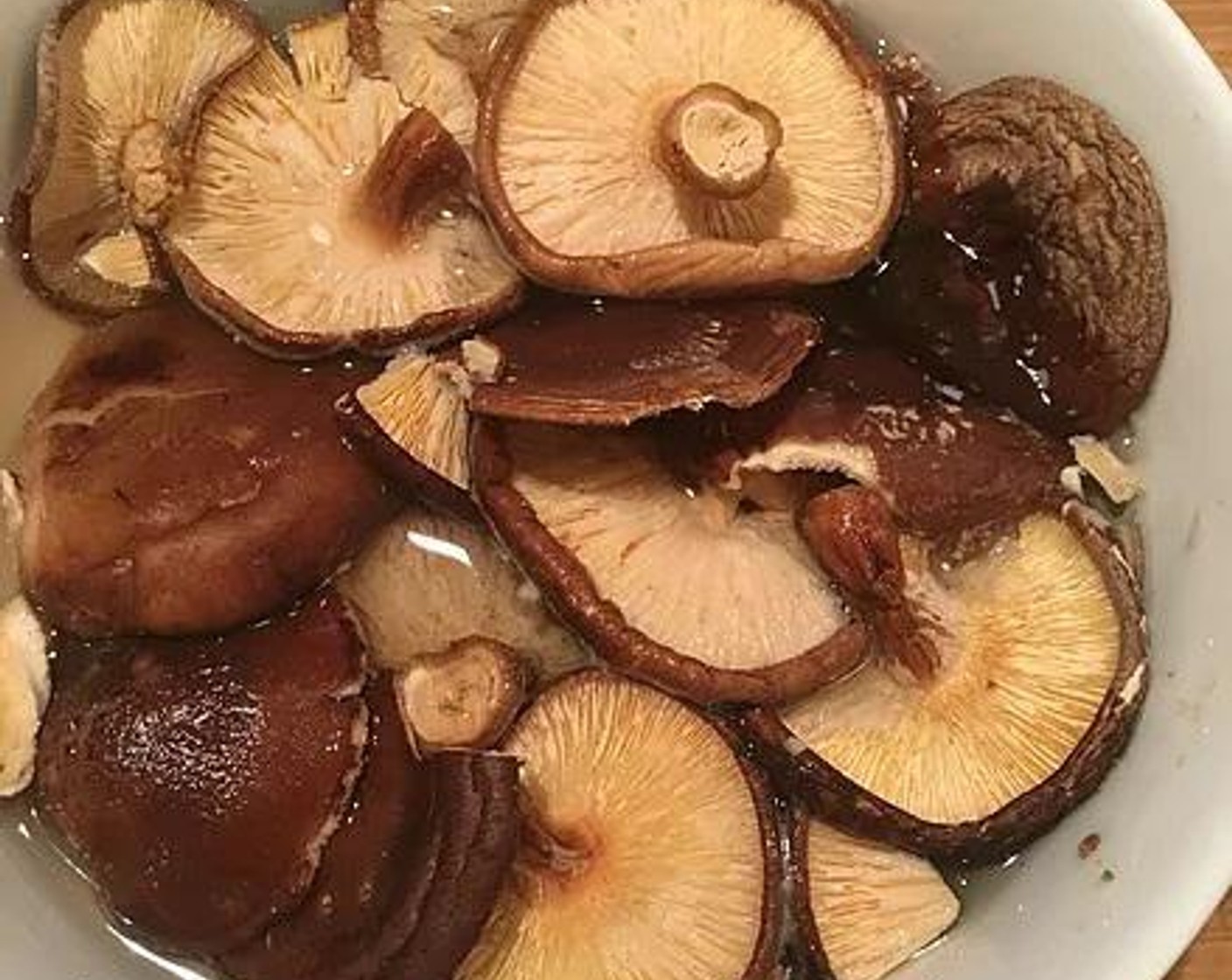step 3 Place the Dried Shiitake Mushrooms (10) in a bowl and cover with water.  Let it soak for 30 minutes to rehydrate.  Once hydrated, the mushrooms will feel soft.  Squeeze out the excess moisture and thinly slice into strips.