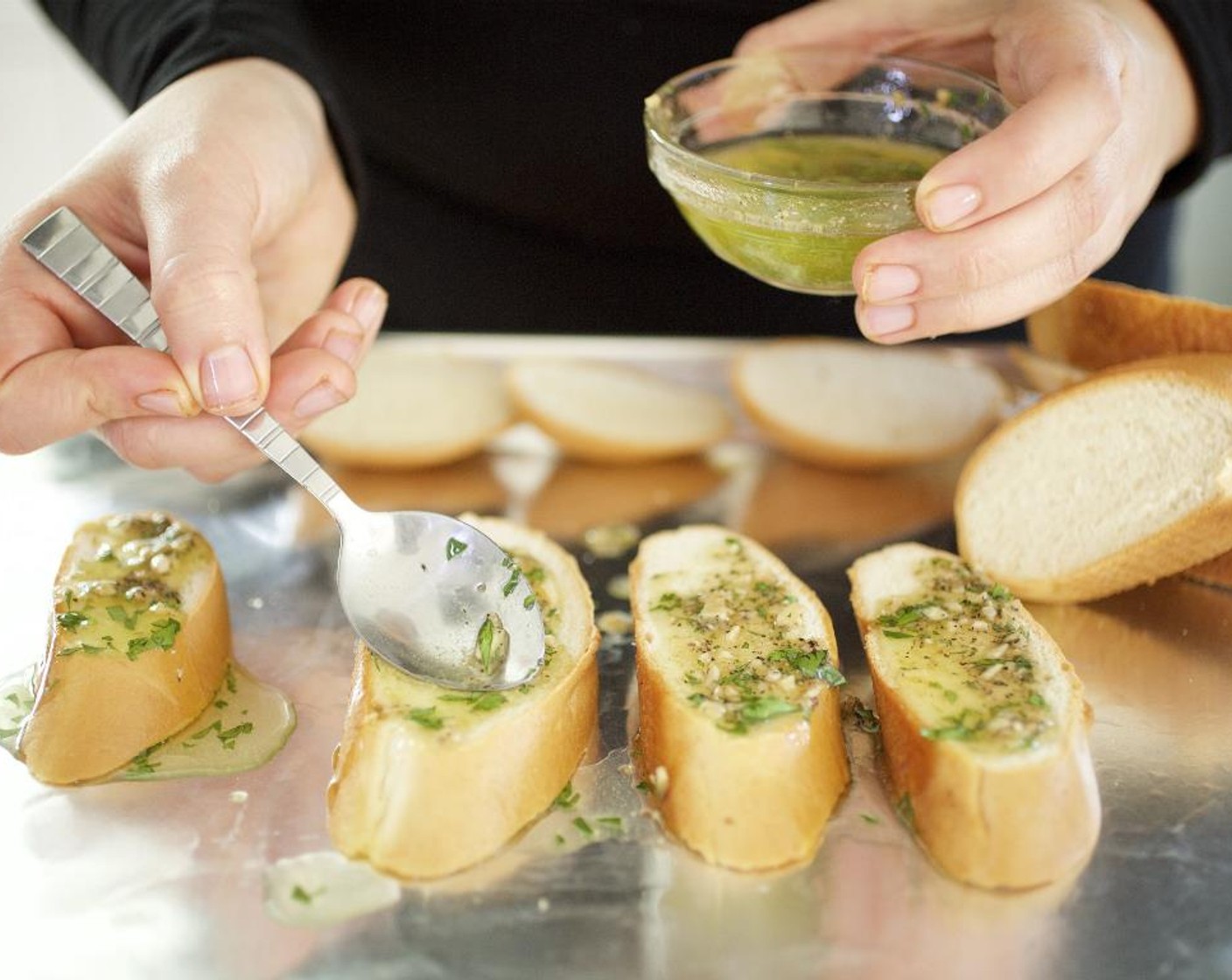 step 16 Spread garlic mixture on one side of each  baguette slice; place on baking sheet. Bake in the oven for 8 to 10 minutes until the bread has browned slightly.