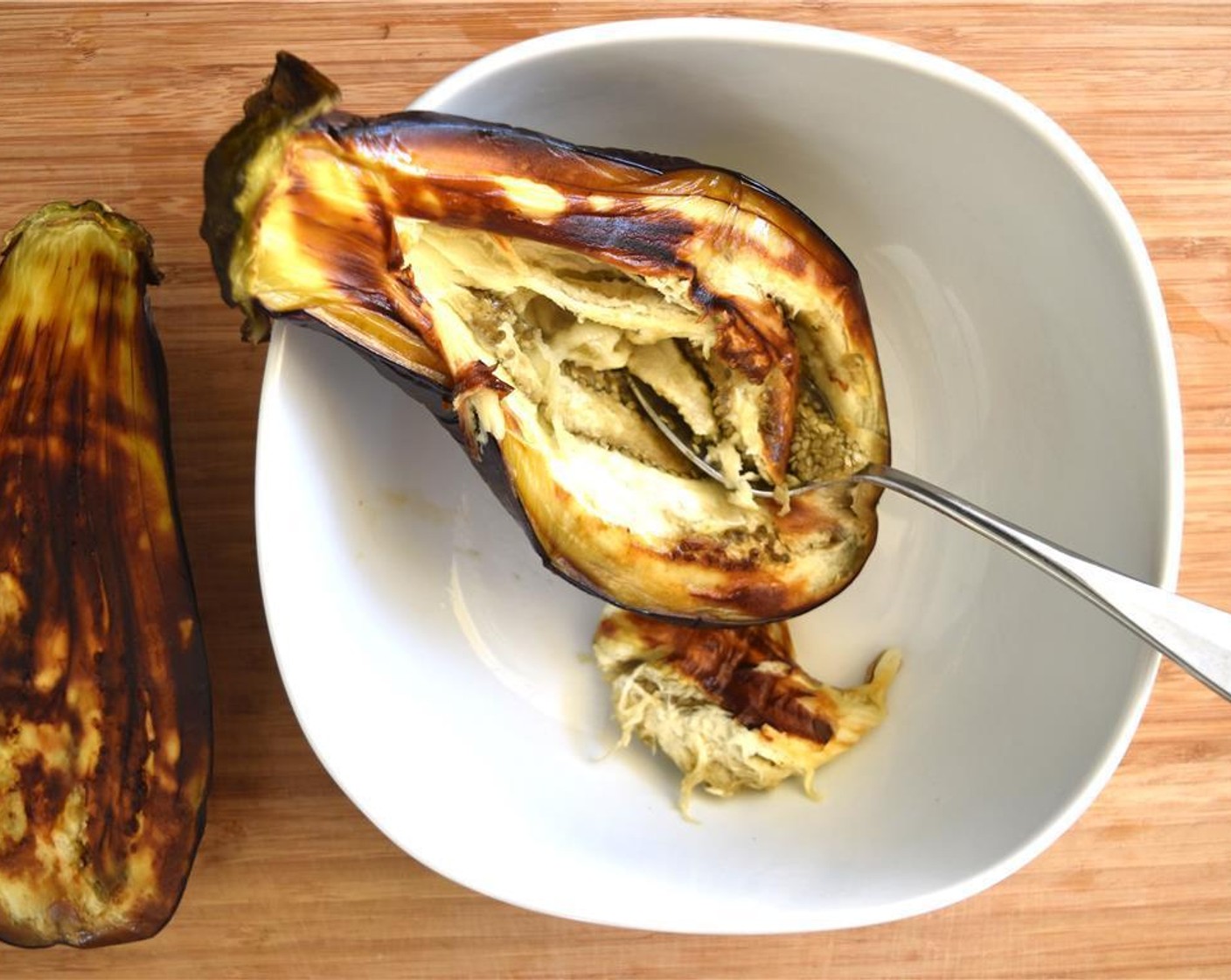 step 2 Scoop out eggplant from the skin with a spoon. Mix in a bowl with Garlic (2 cloves), juice of the Lemon (1), Tahini (1/3 cup) and Italian Flat-Leaf Parsley (1 handful). Add Salt (1/2 tsp).