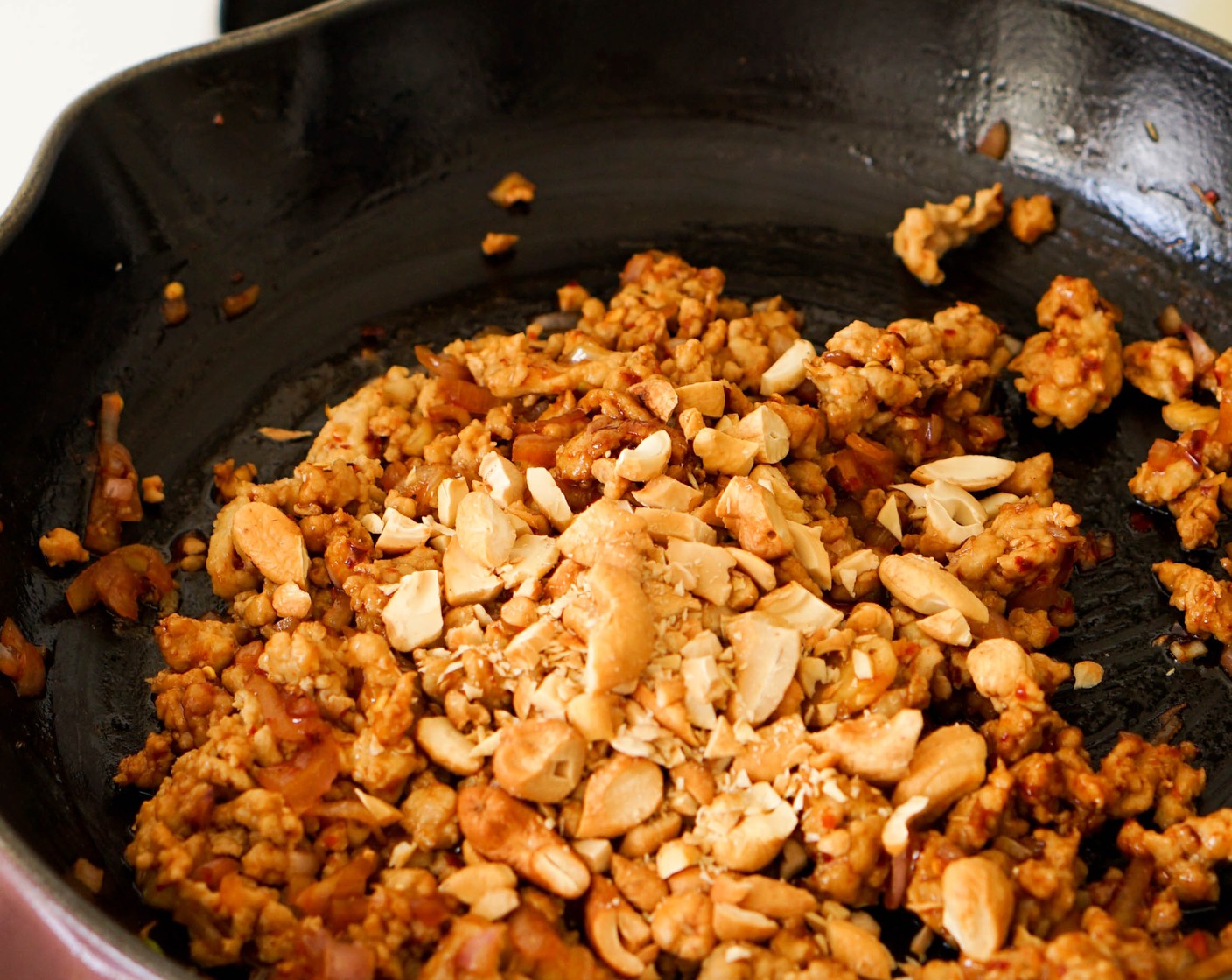 step 1 Heat Olive Oil (2 Tbsp) in a skillet over medium-high heat. Add the Ground Chicken (8 oz) to the pan and season with Crushed Red Pepper Flakes (1 tsp), Kosher Salt (1/2 tsp), Granulated Sugar (1 tsp), and Fish Sauce (1 Tbsp). Using a spatula, break up the ground chicken into small crumbles and toss to evenly coat in the seasonings. Continue to cook for 5 minutes, until the chicken is mostly cooked through.