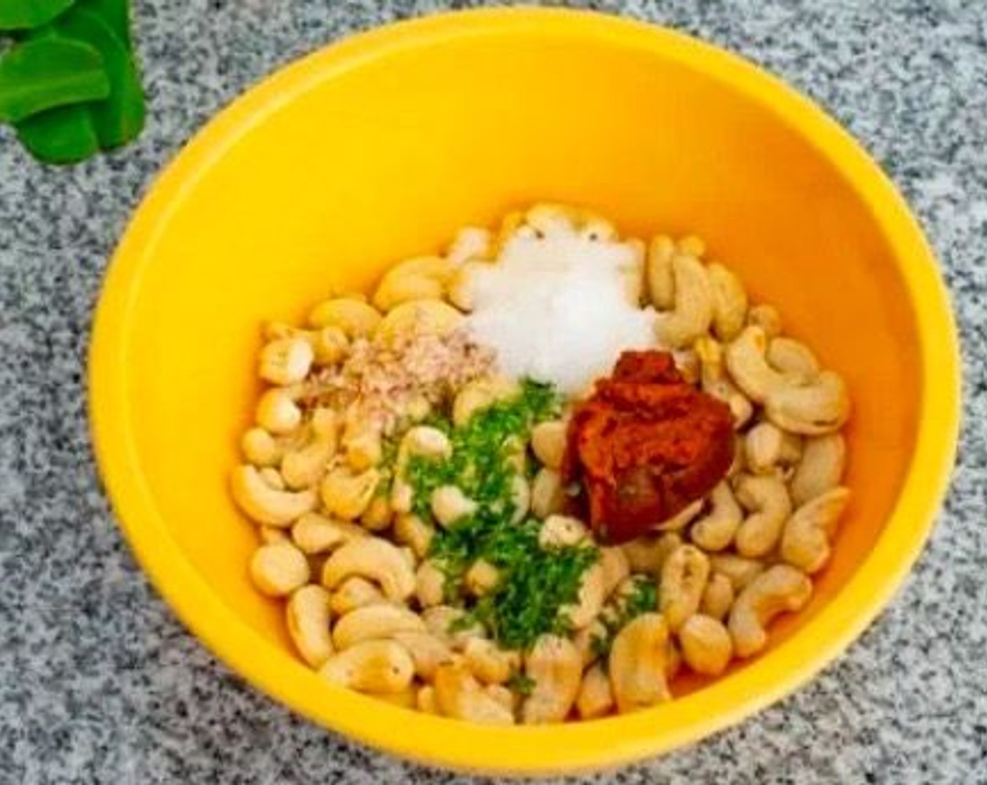step 2 In a bowl, combine Raw Cashews (1 3/4 cups), Tom Yum Chili Paste (1 Tbsp), Coconut Oil (1 Tbsp), juice from Lime (1/2), Granulated Sugar (2 tsp), Fresh Cilantro (1 tsp), and the white portion of the Lemongrass (1 stalk). Stir well until all of the cashew nuts are coated.