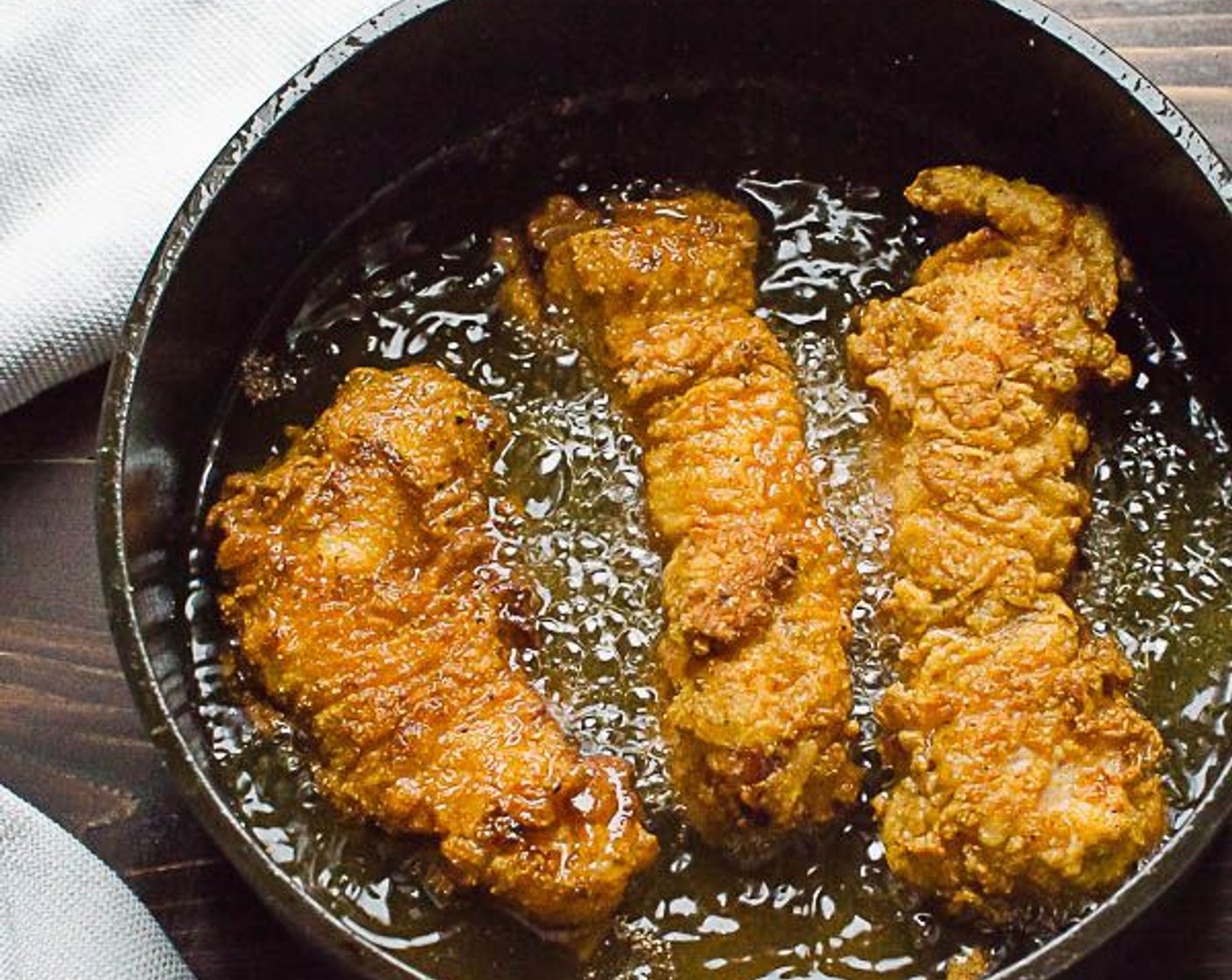 step 8 Tap off excess flour and gently place chicken strips into the hot oil. Do not crowd the pan.