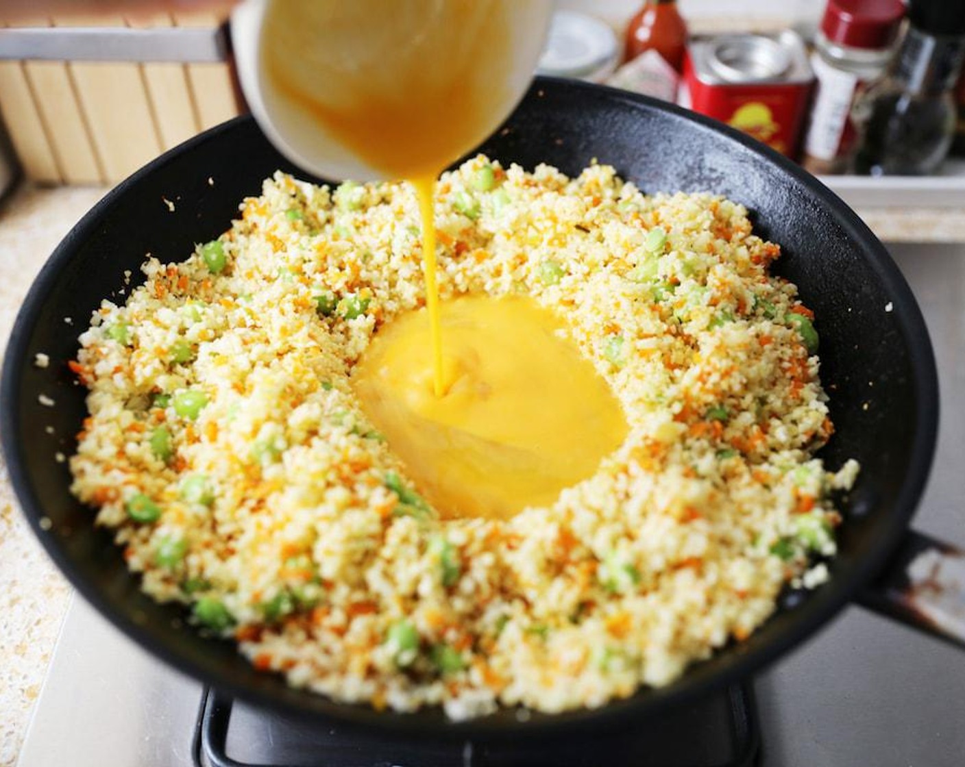 step 5 Make a well in the middle of the wok and add the Egg (1). Stir until the egg is scrambled and then mix into the rest of the cauliflower rice.